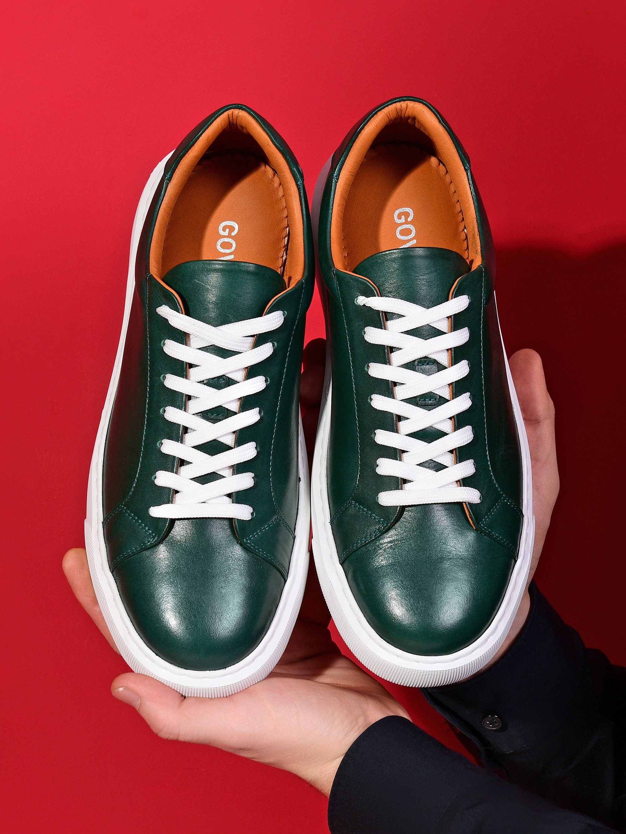 кроссовки зеленого цвета в руках у модели