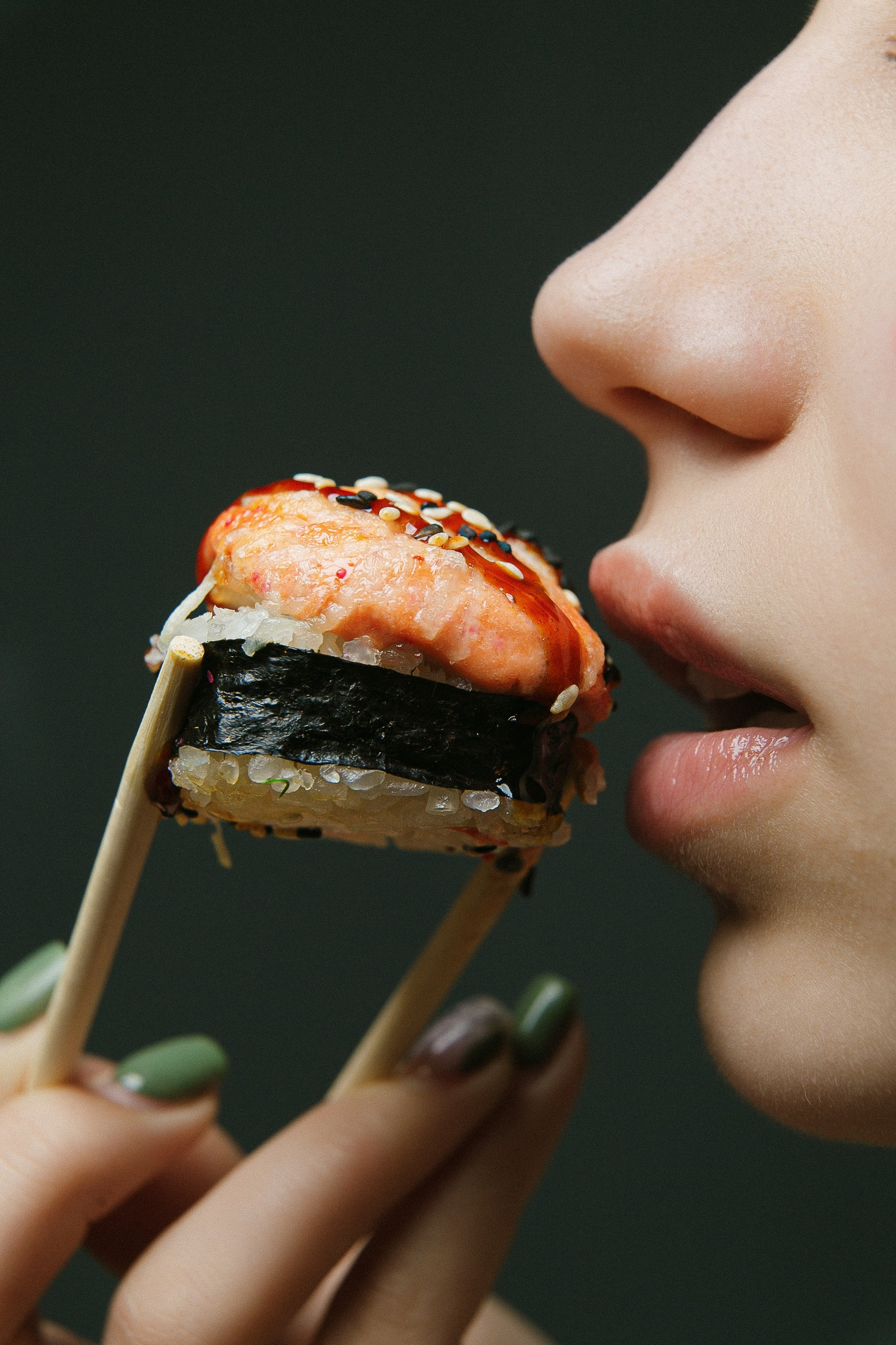 Аппетитный ролл в руке с палочками — профессиональная фуд-фотосъёмка для ресторанов