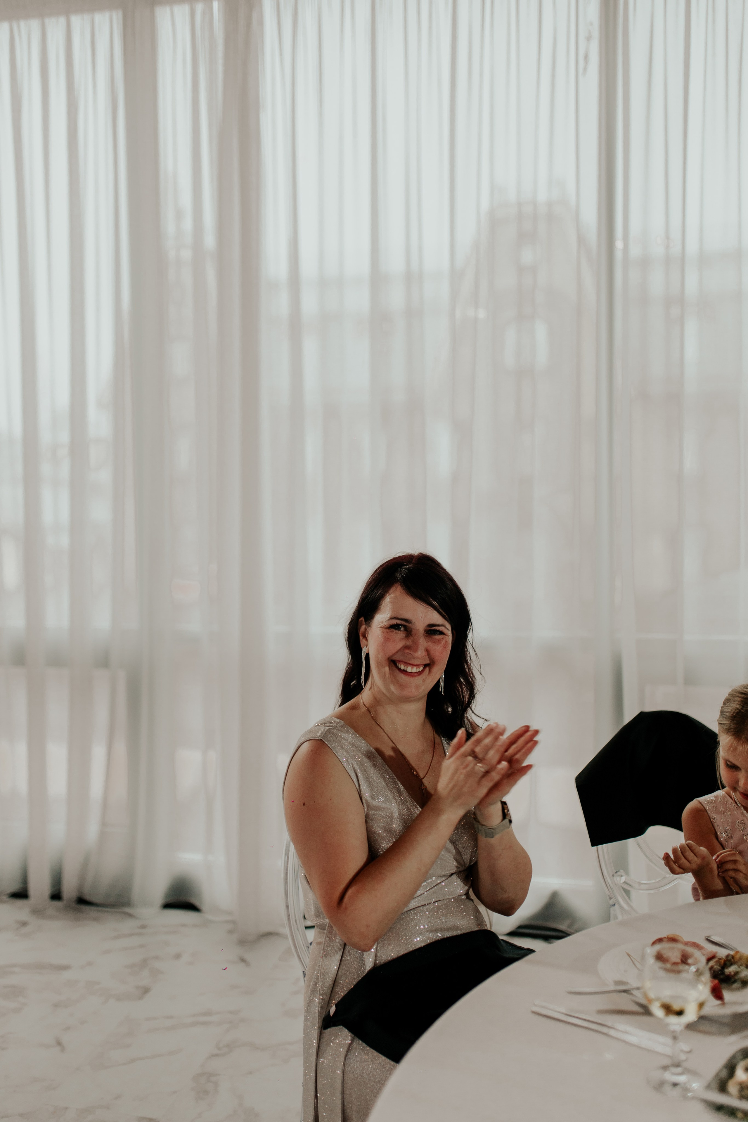 Мама невесты внимательно слушает речь на свадебном банкете — нежный взгляд