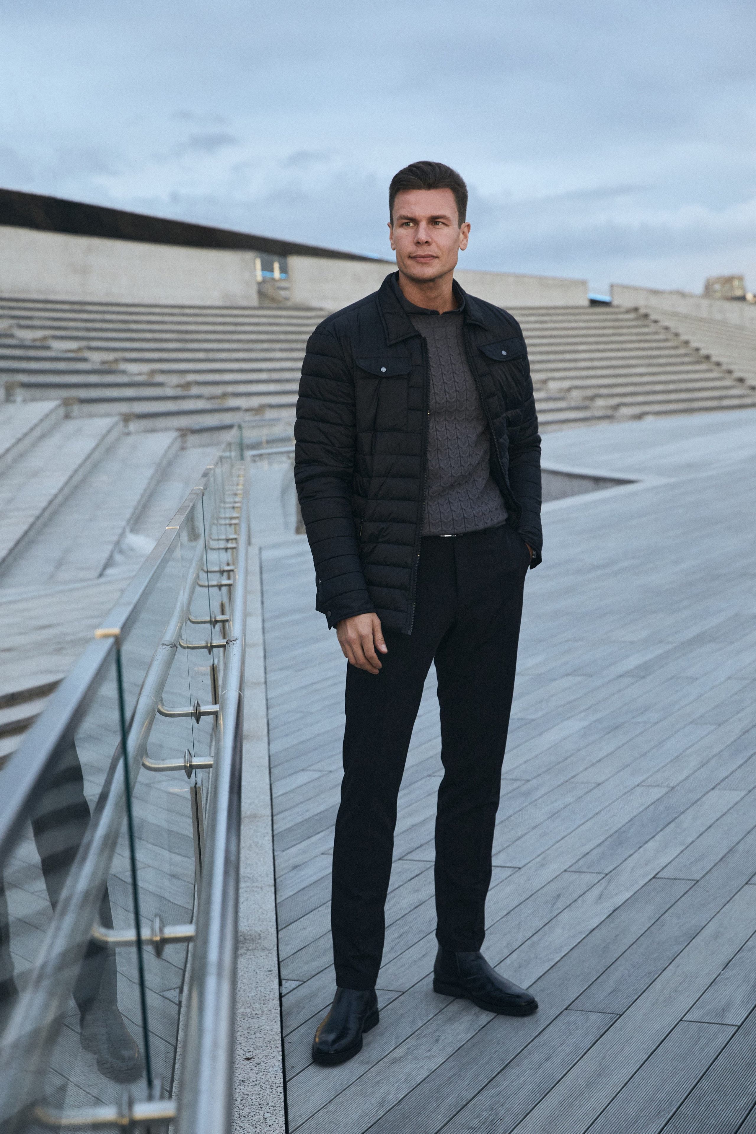 Мужчина модель в черной стеганой куртке и штанах