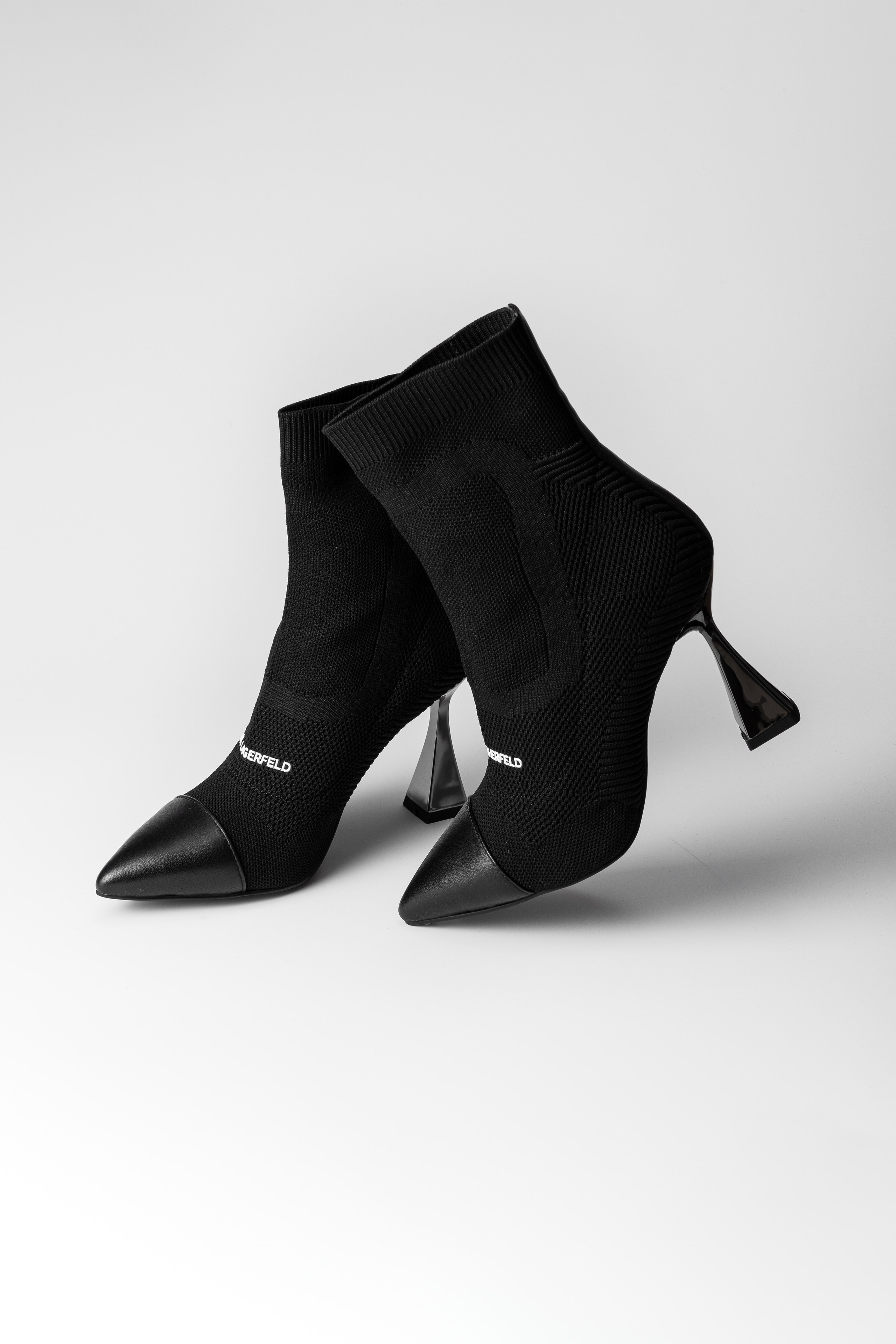 Пара женских полусапог на каблуке на белом нейтральном фоне