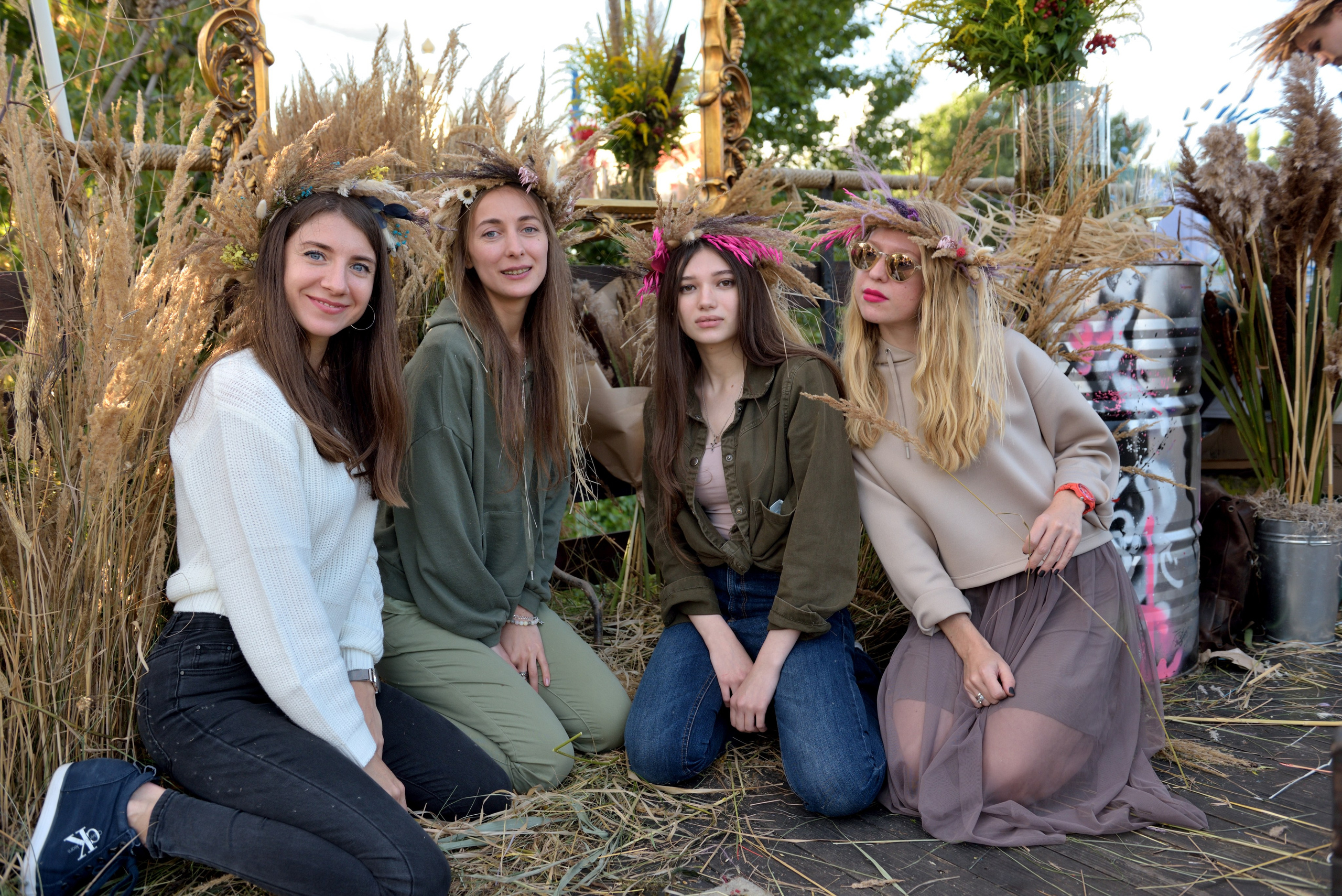 "Девушки позируют в венках из колосков на мероприятии".