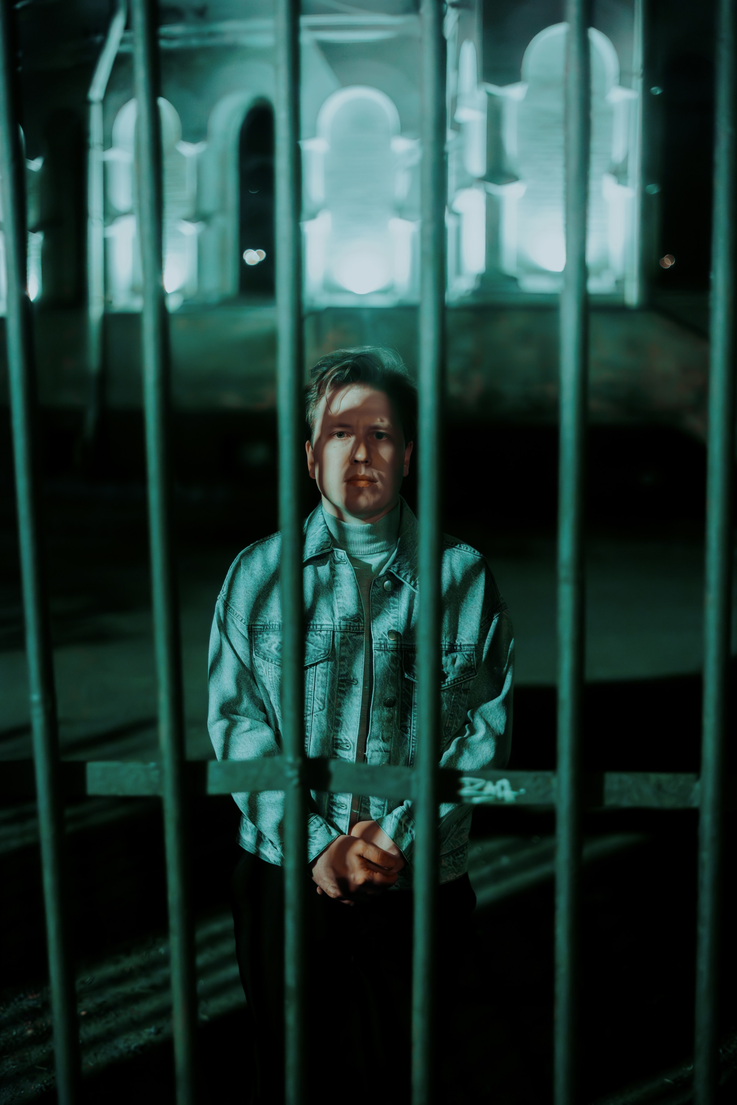 Мужчина с тенью на лице за решеткой дальним планом 