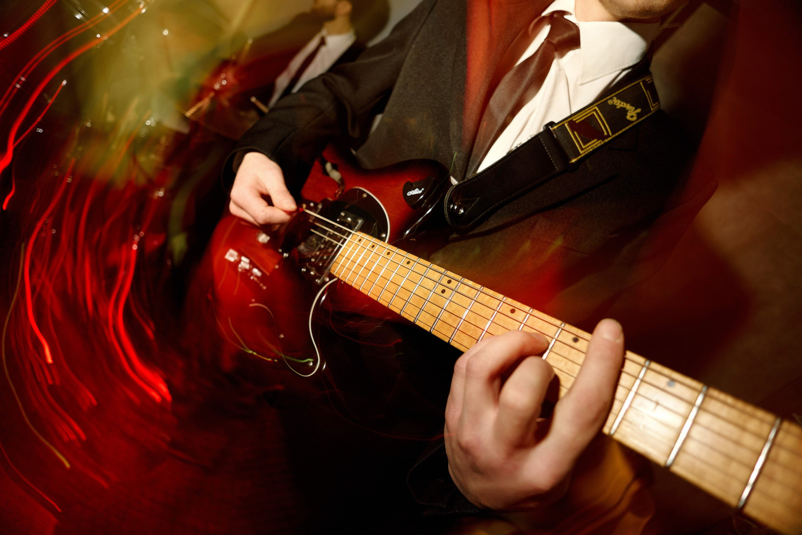 Музыкант играет на электрогитаре на праздничном мероприятии