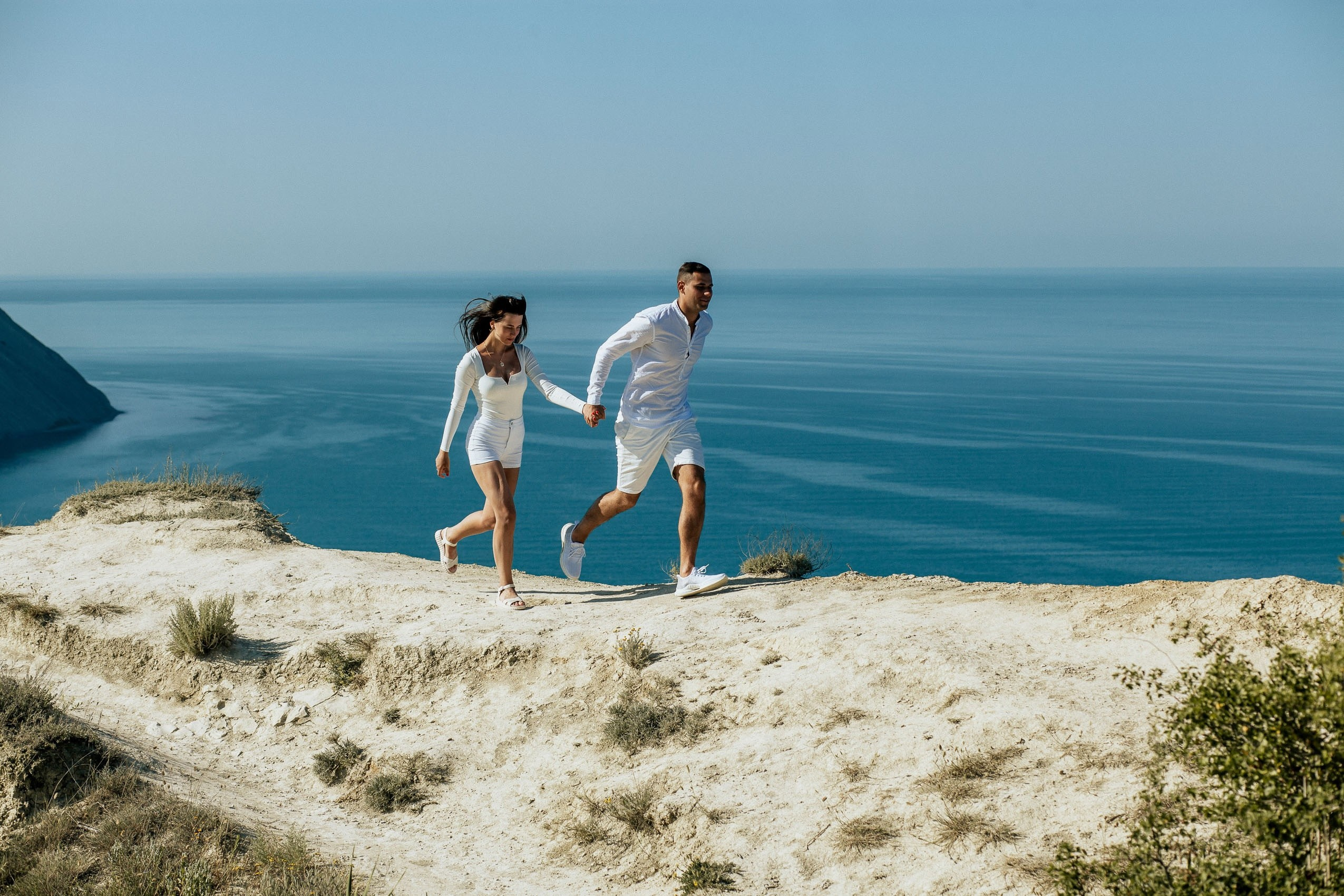 Прогулка по Лысой Горе в Анапе, бегущие молодые люди на фоне моря.