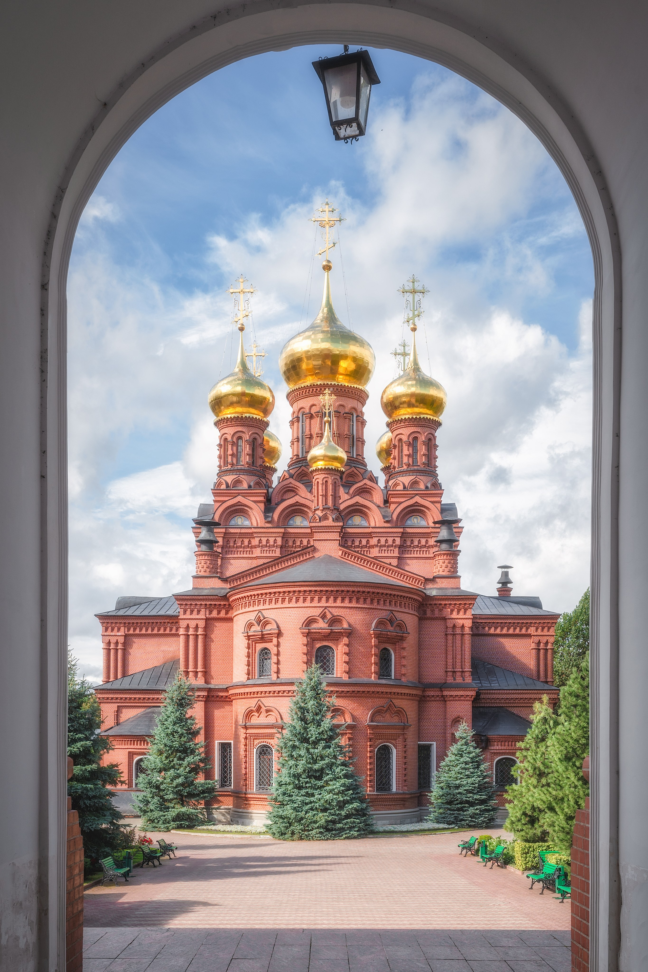 Вид на Черниговский храм в Сергиевом Посаде через арку, на фоне белых облаков