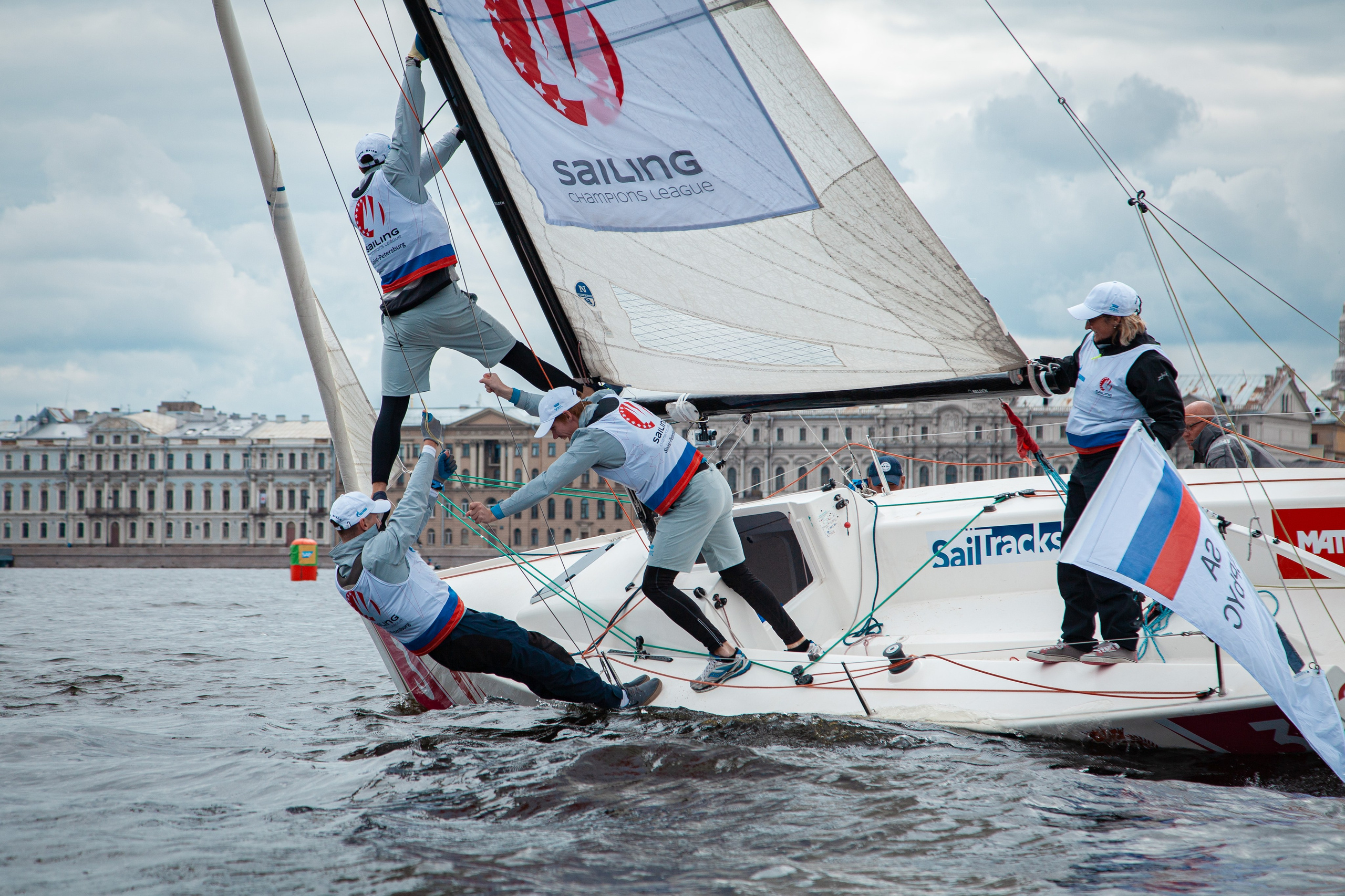 Российская команда яхтсменов накренивает лодку.