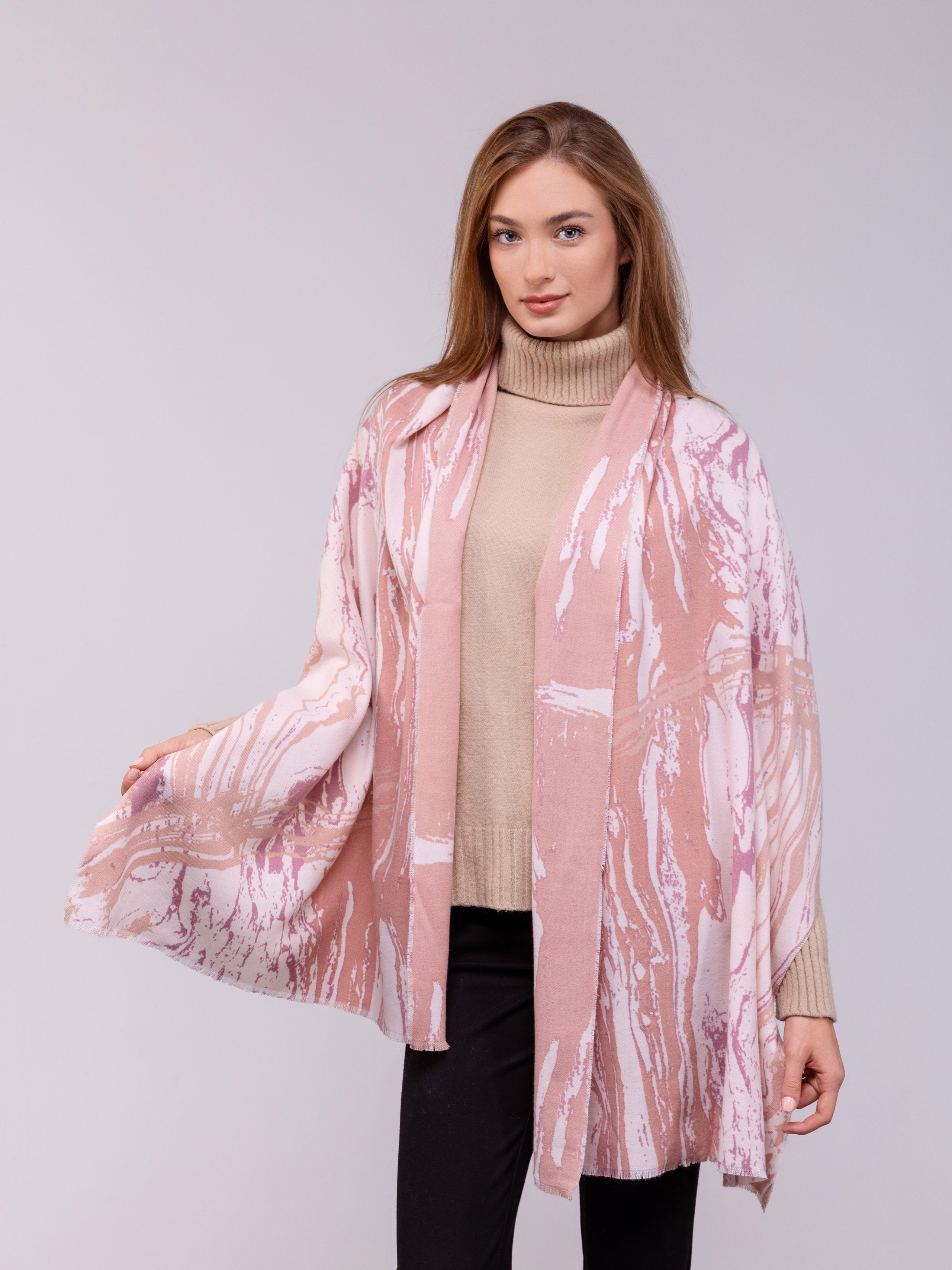 Девушка демонстрирует большой розово-белый шарф.