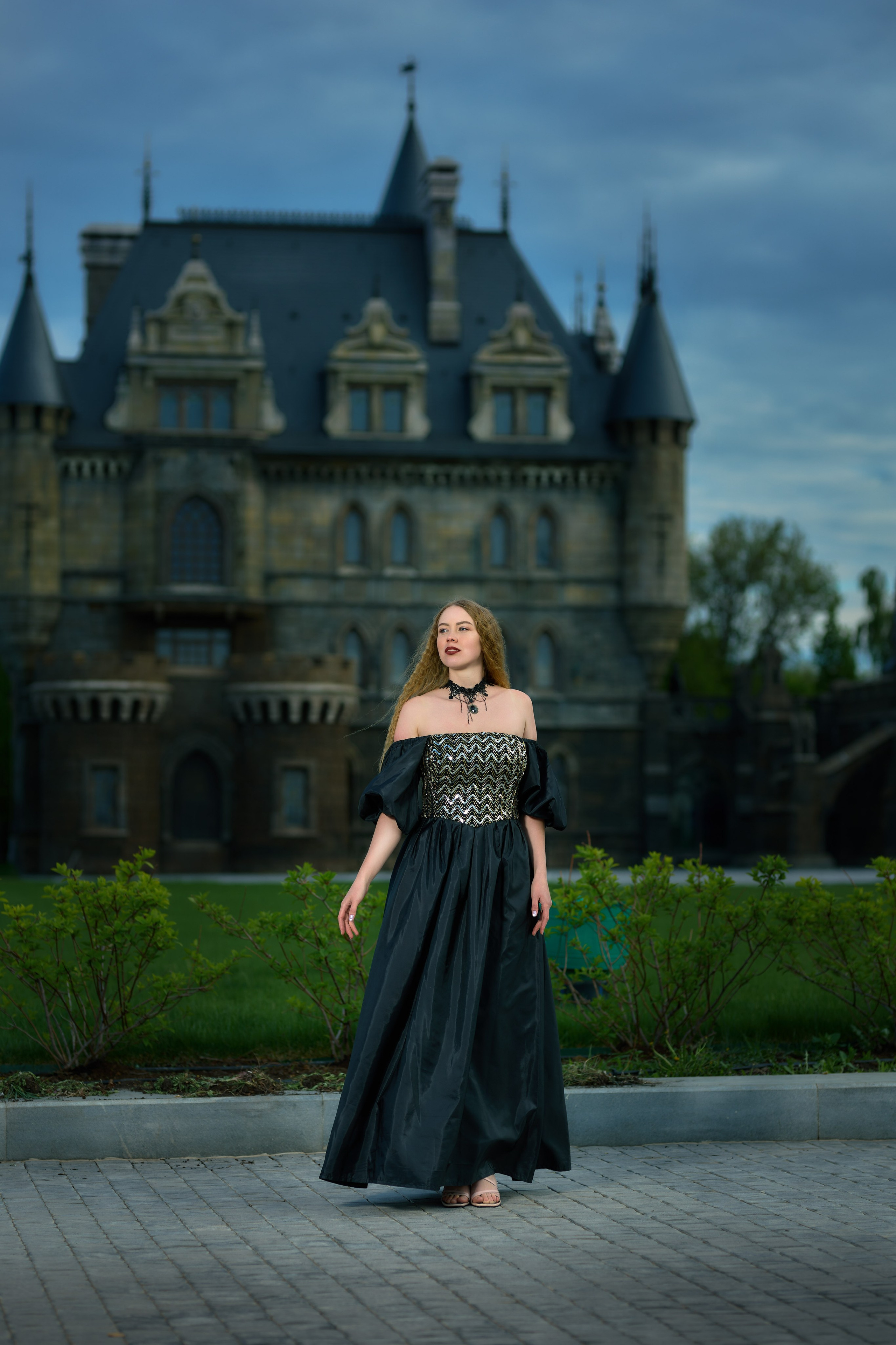 Девушка в винтажном платье стоит на фоне замка Гарибальди