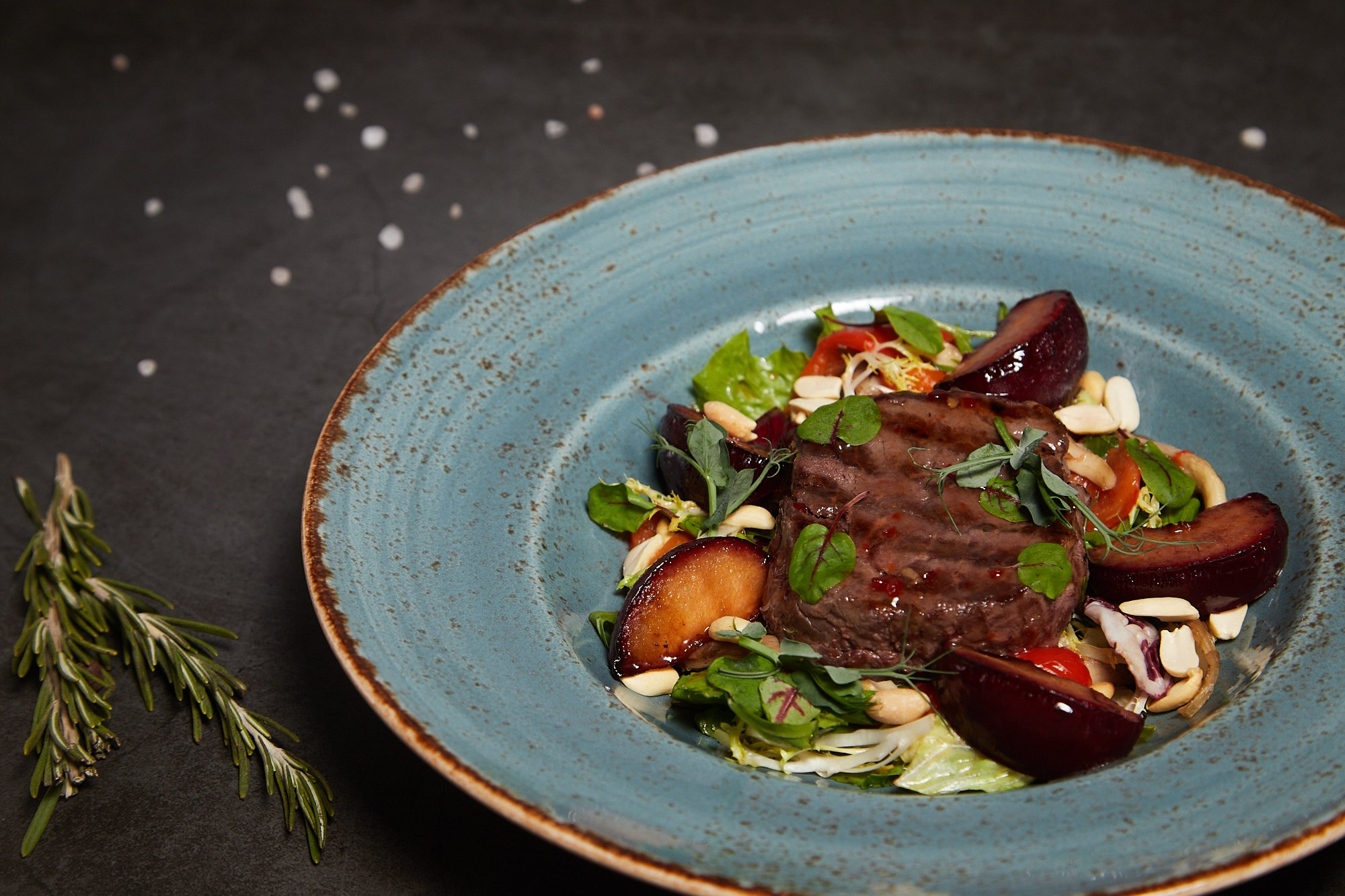 Фуд-фотография салата с печёными овощами и зеленью.