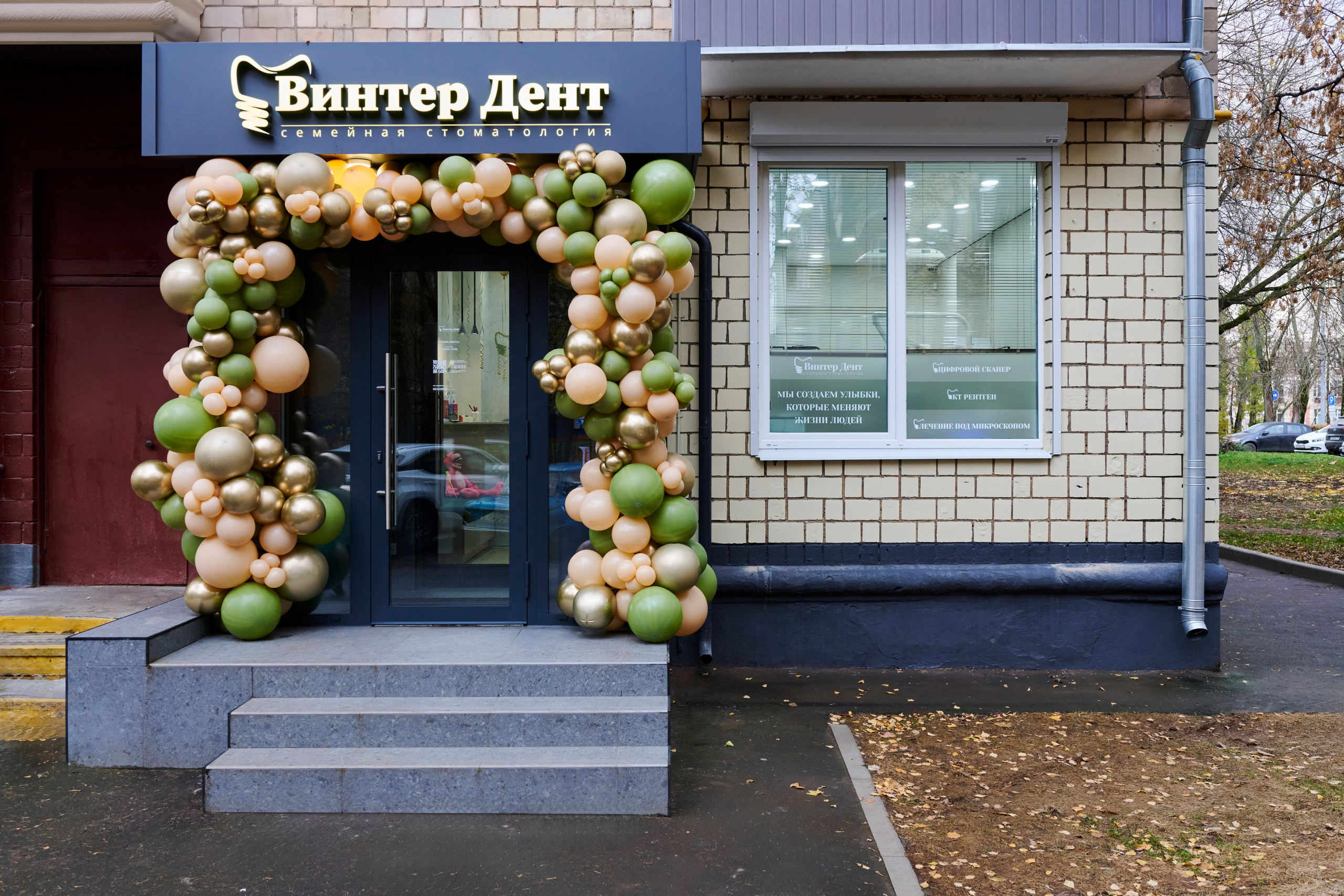 Вход в клинику Winter Dent: вывеска, арка из шаров