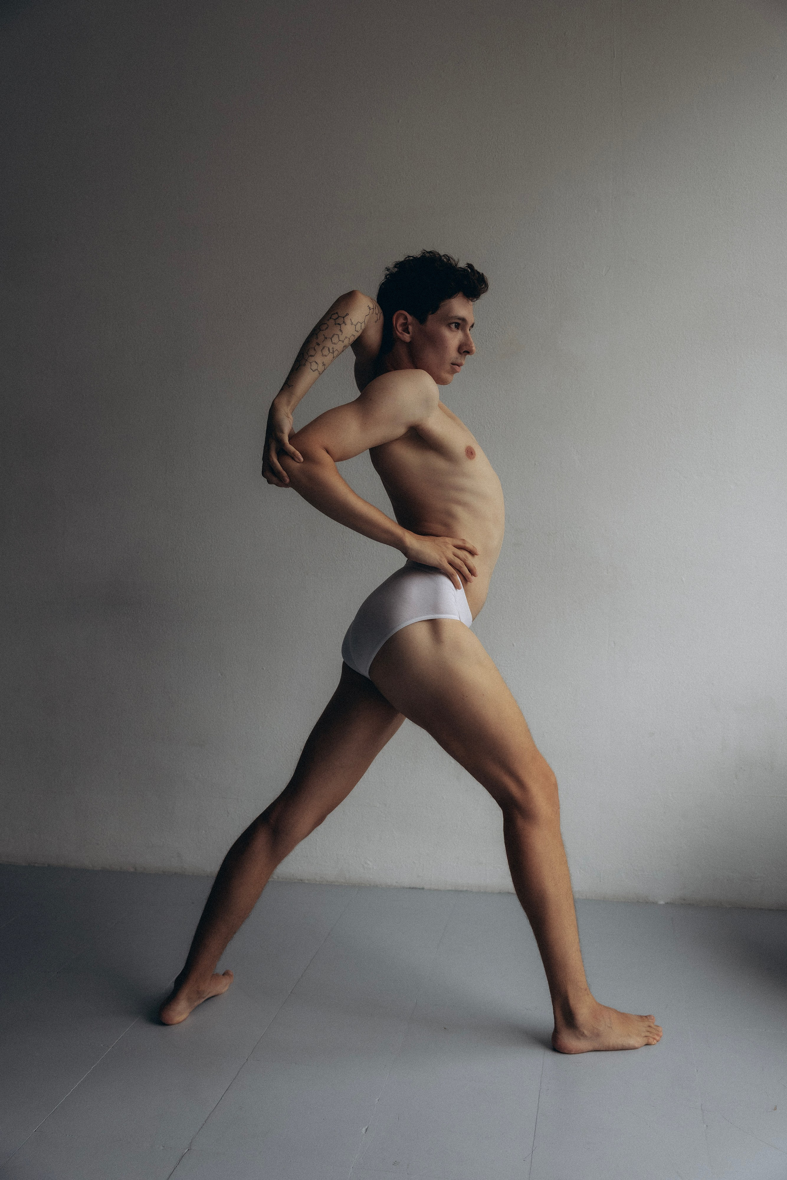 Artistic black and white portrait of a smiling man behind a curtain in Barcelona