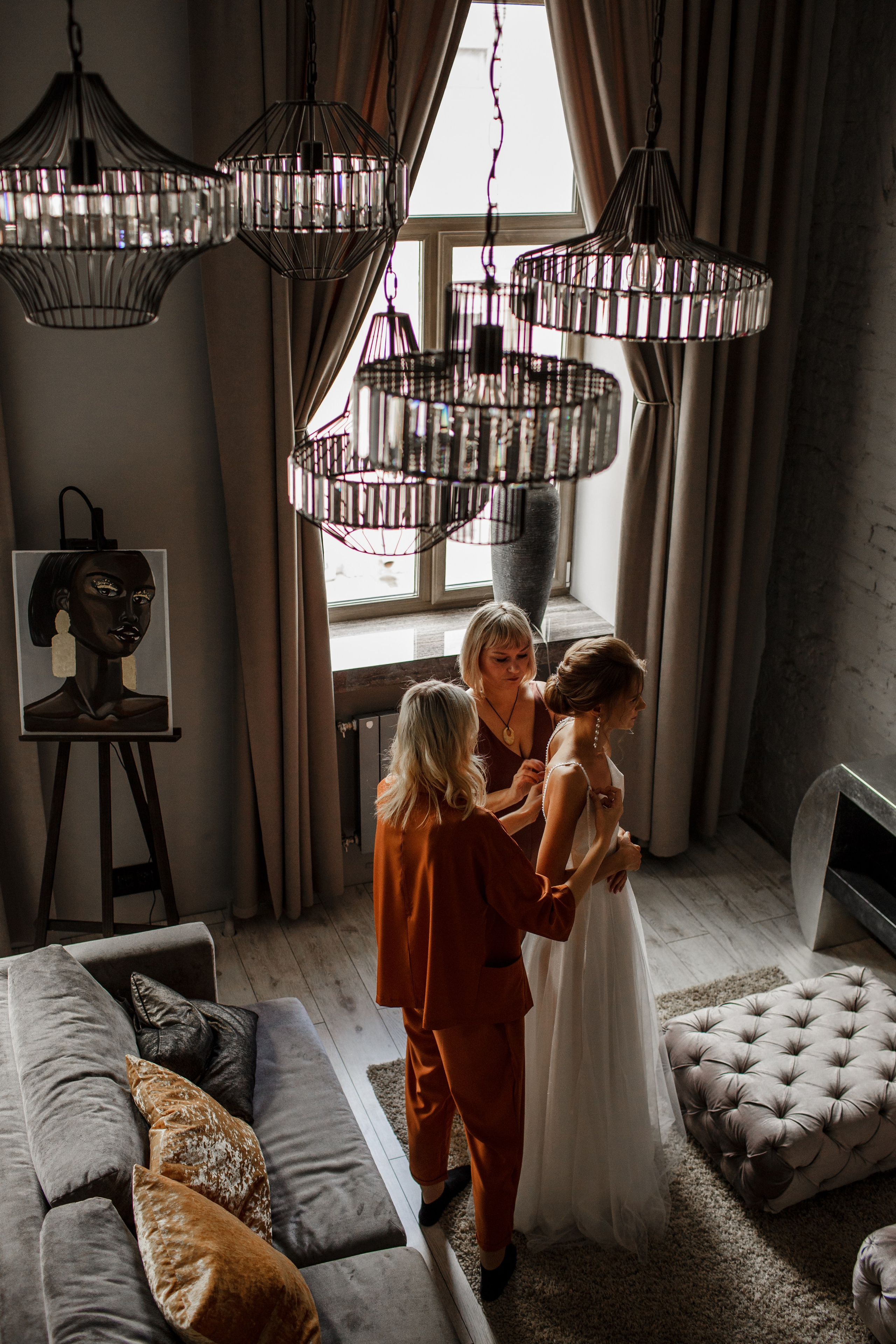 Сборы невесты в лофте Санкт-Петербурга: мама помогает невесте надеть платье.