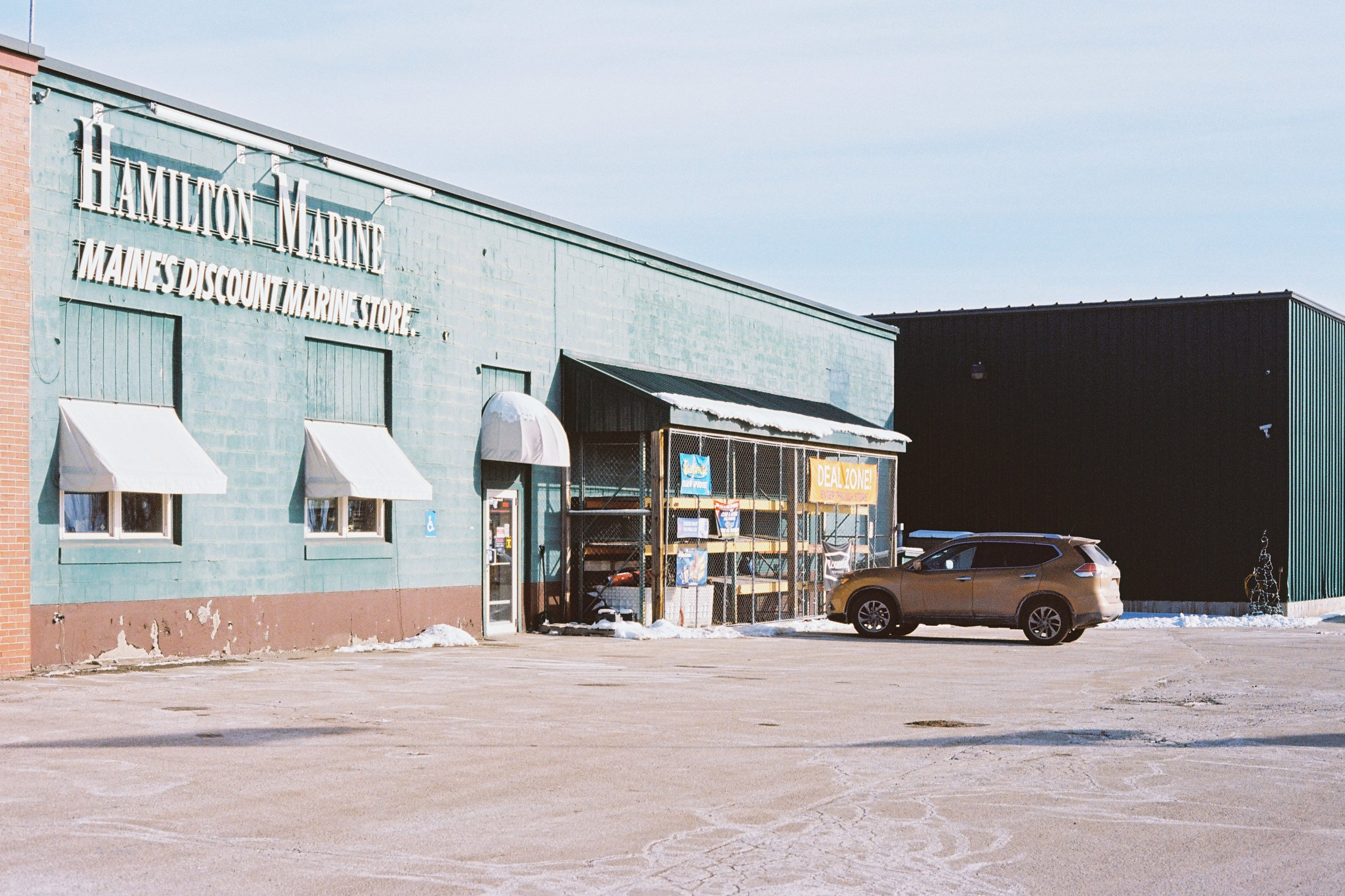 Городской пейзаж, авто припарковано у магазина рыболовных товаров