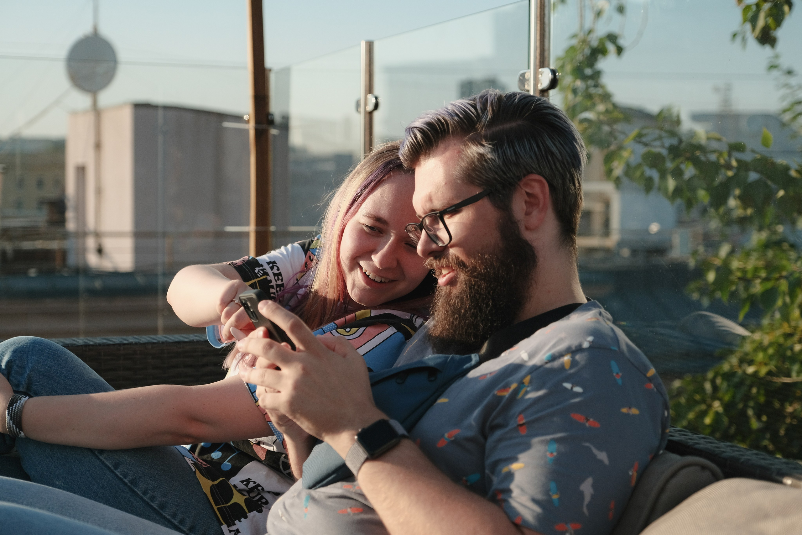 Парень с бородой и девушка на вечеринке разговаривают.