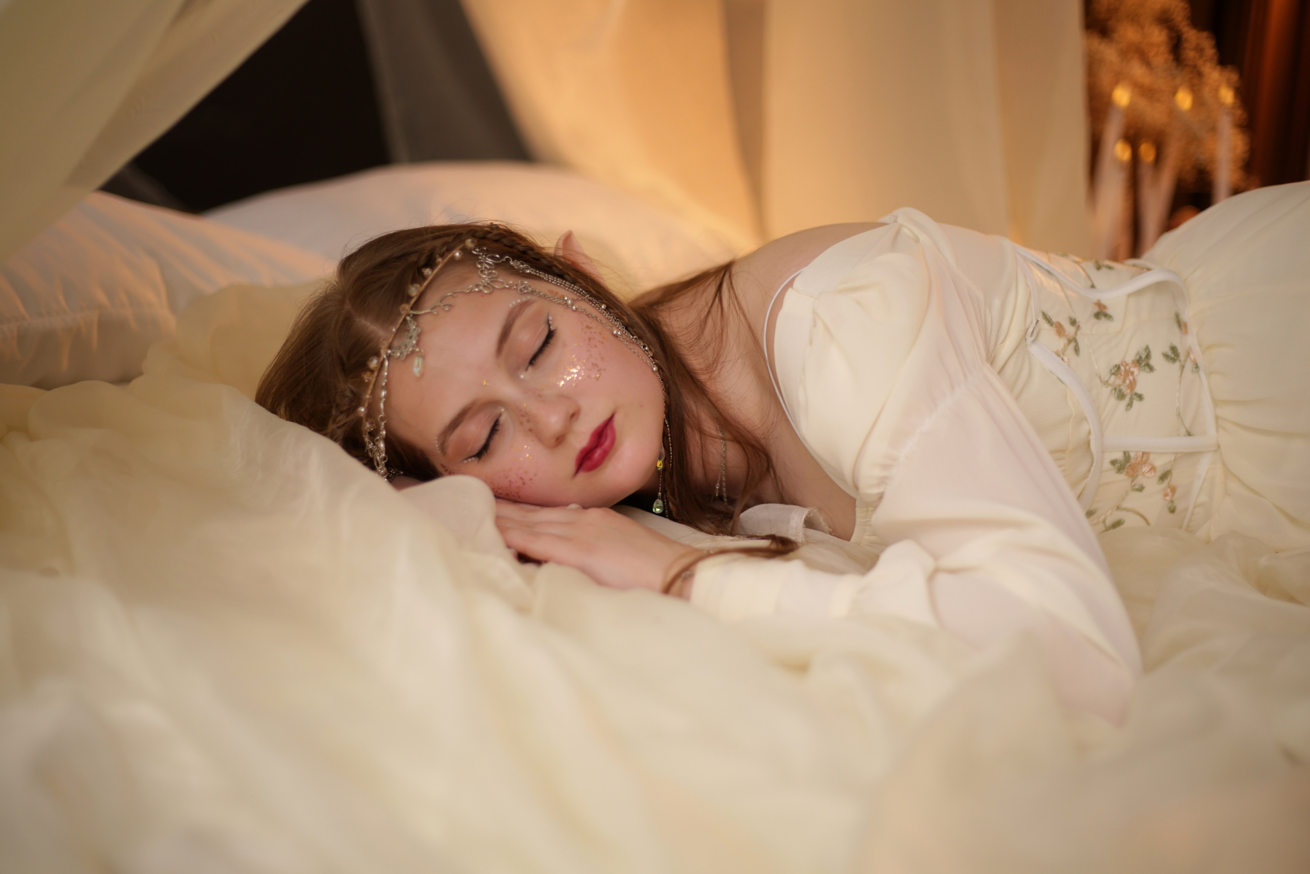 Необычная фотосессия в Перми: девушка в белом платье спит на кровати под балдахином, лицо украшено блестками