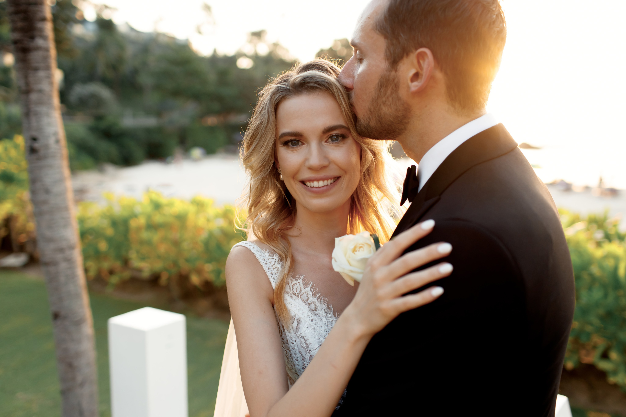 жених целует невесту на фоне заката на фоне моря