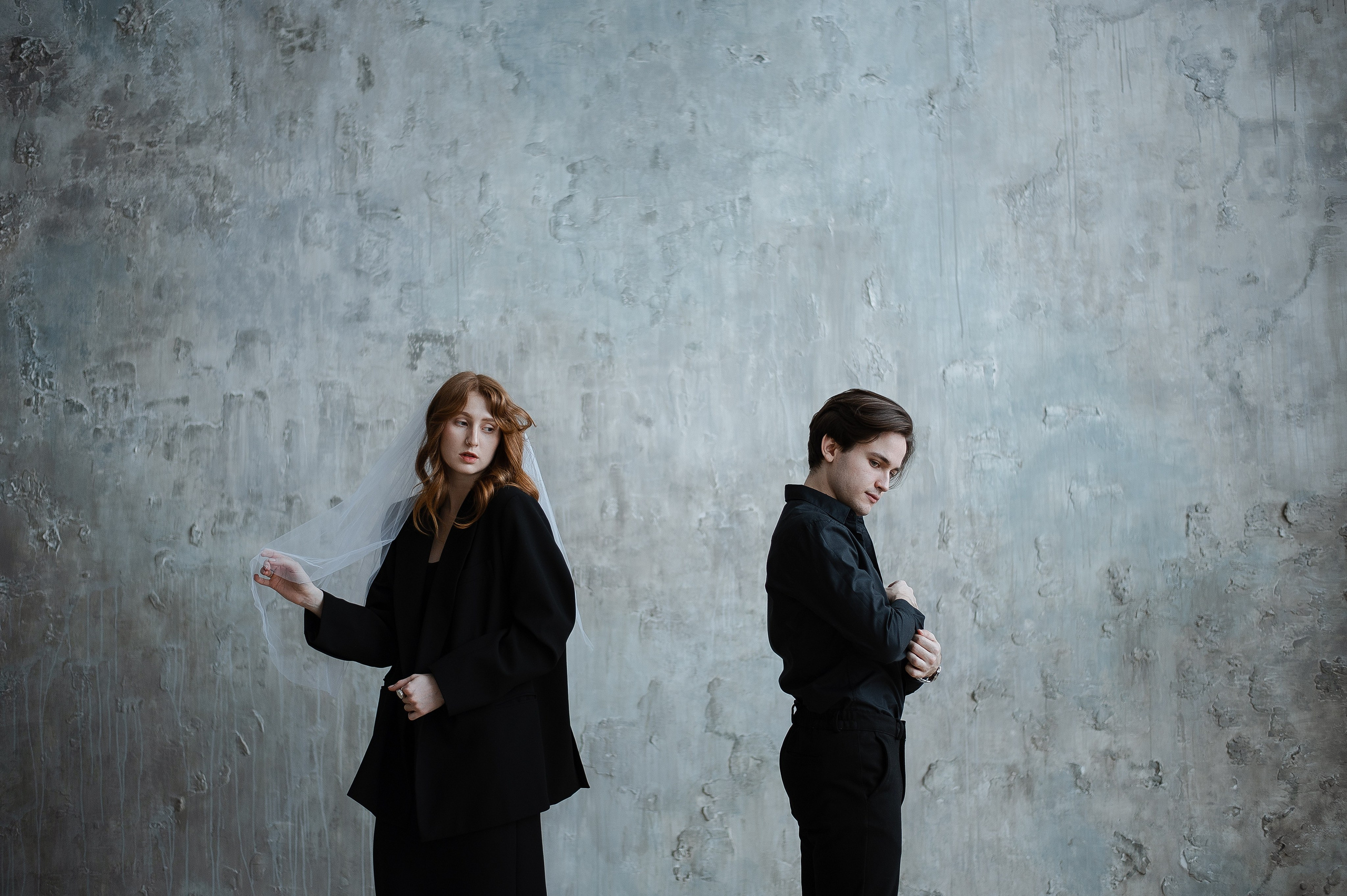 Атмосфераня свадебная пара в студии в лаконичных черных костюмах