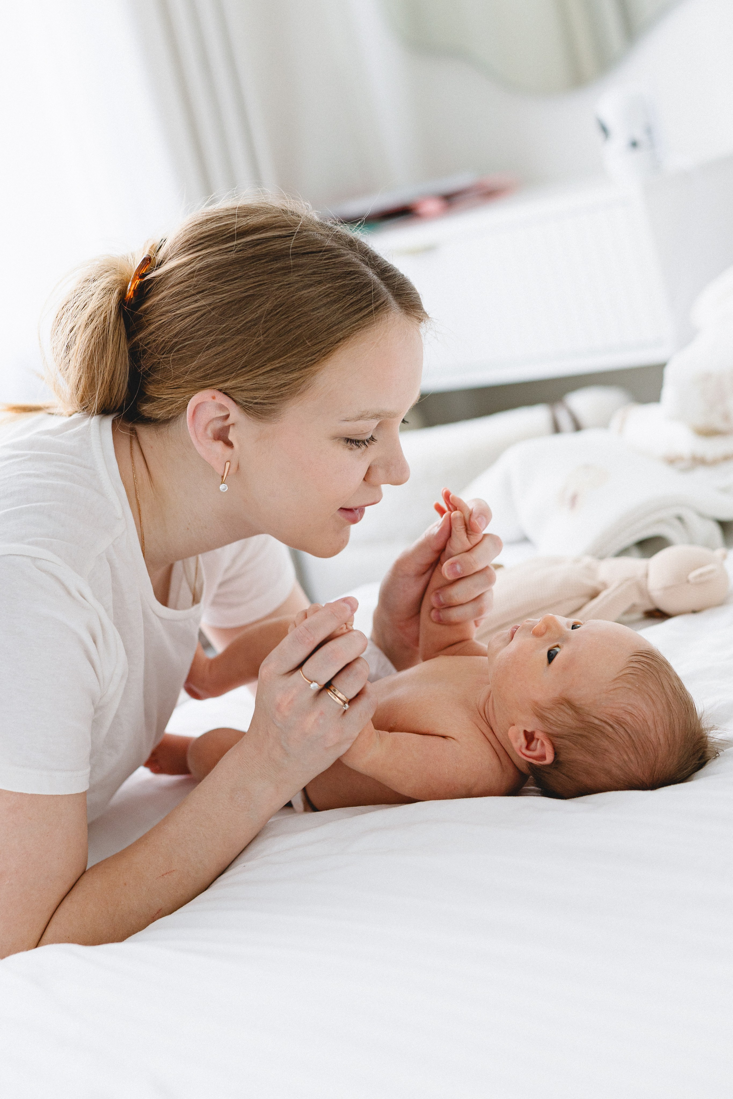 Mother smiling and playing with her baby at home