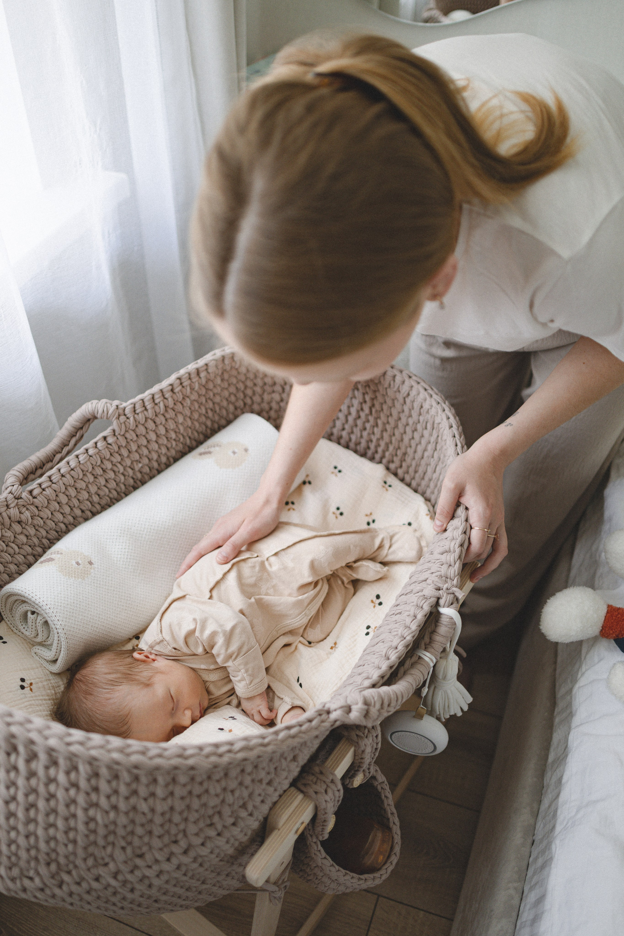 Mother caring for her newborn in a woven bassinet