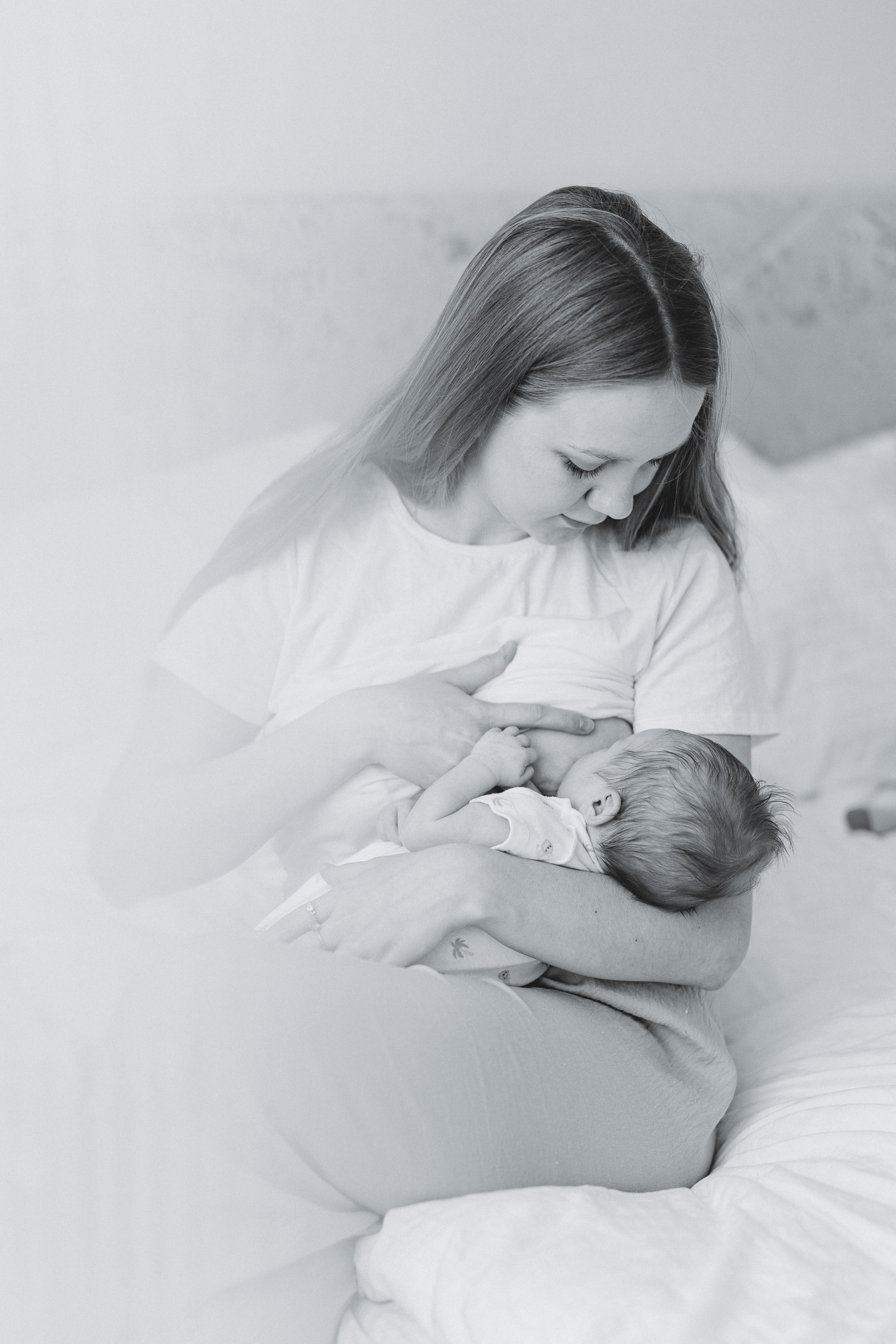 Mother cradling her newborn in a black-and-white portrait