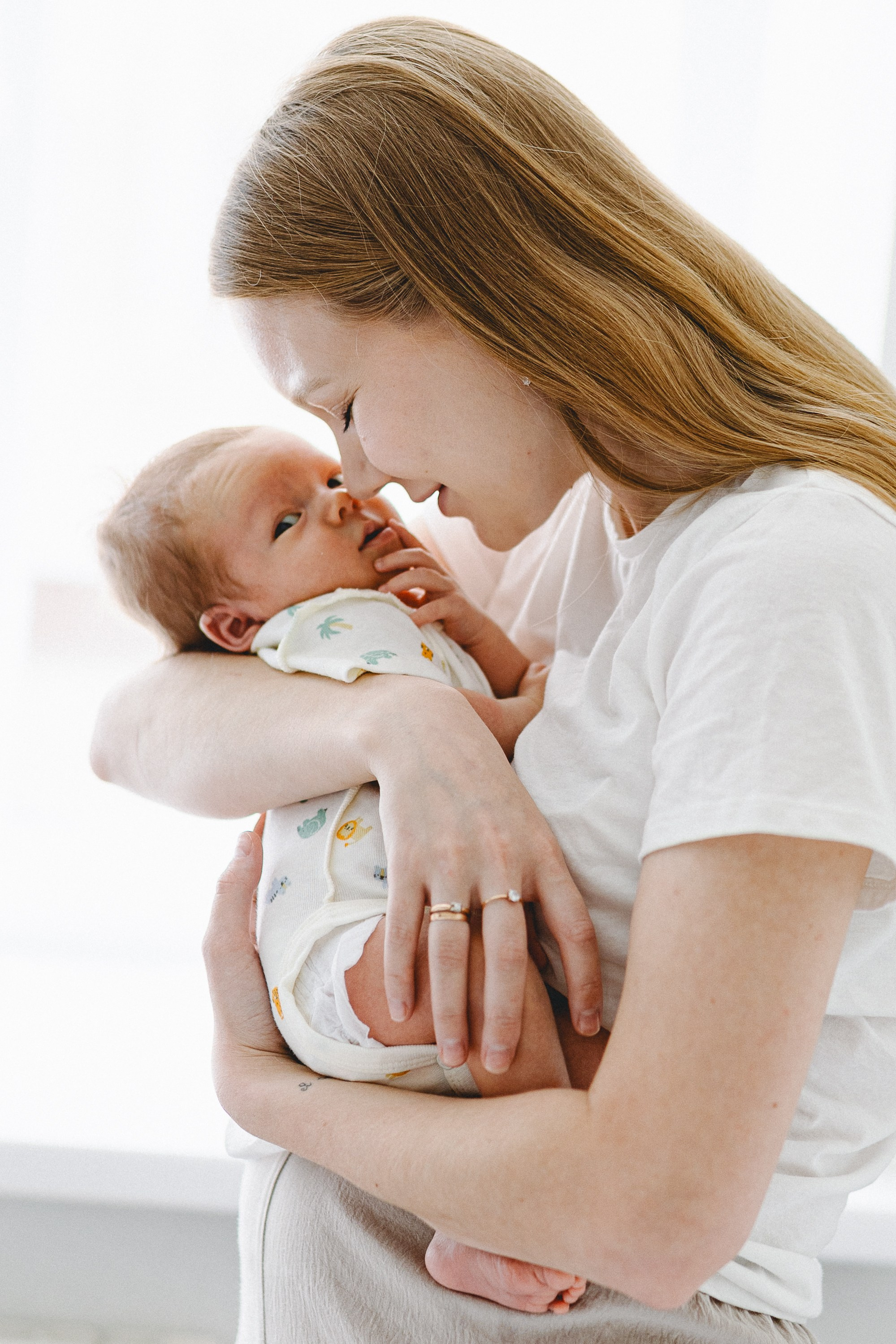 Mother holding her newborn close and touching noses
