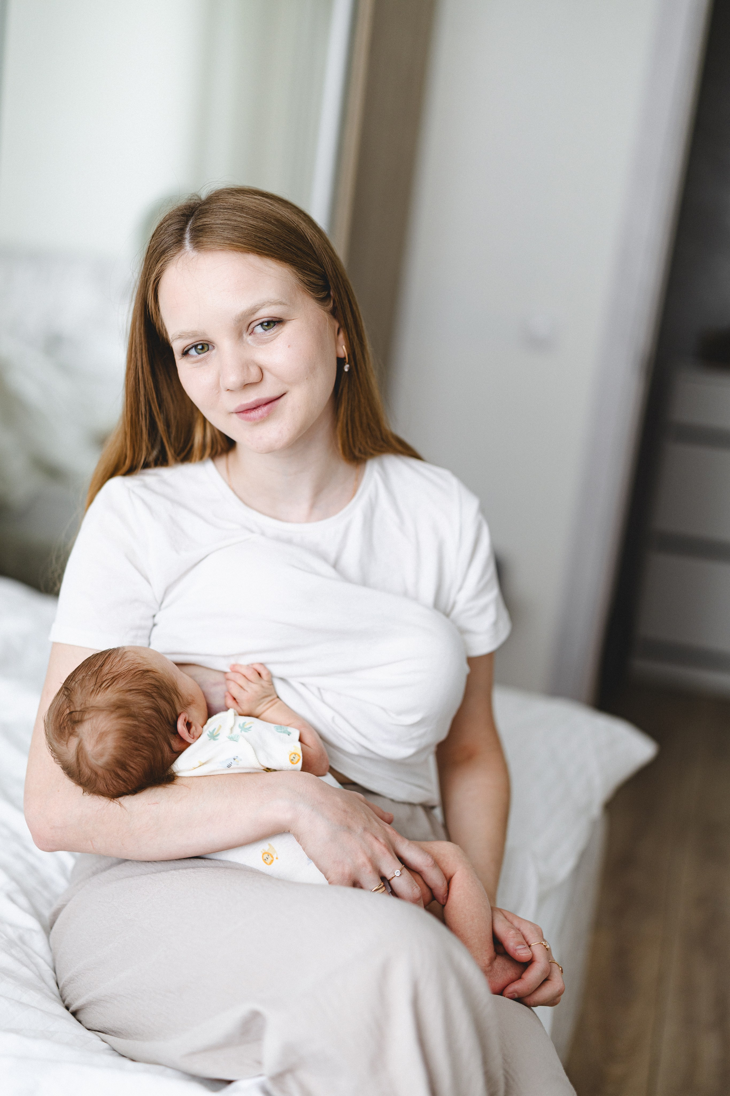 Mother holding her newborn in a natural home portrait