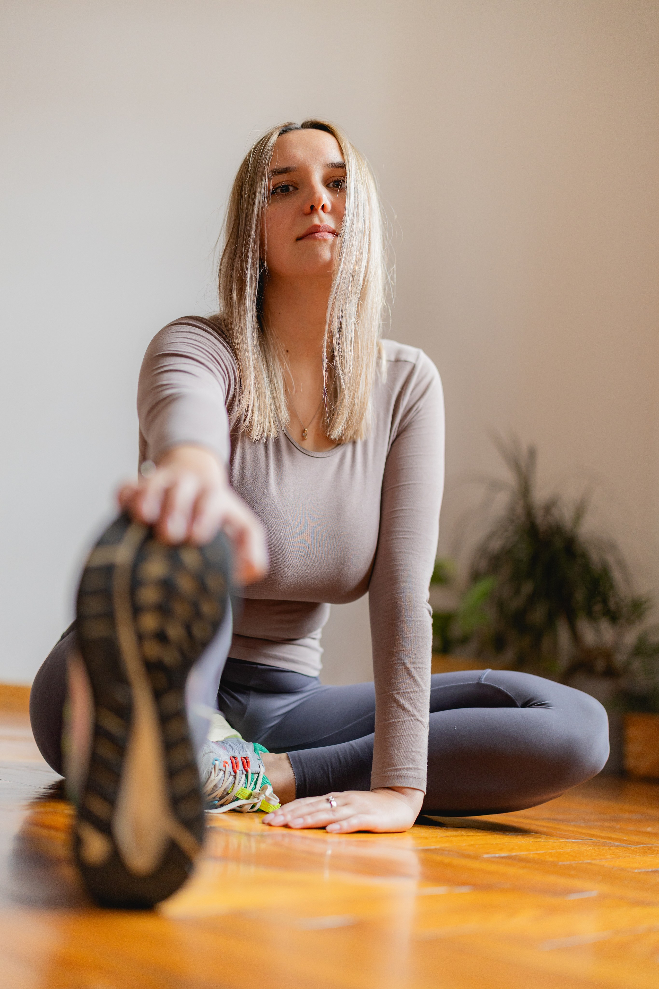 A relaxed female participant sitting on the floor with legs stretched out after an intensive workout