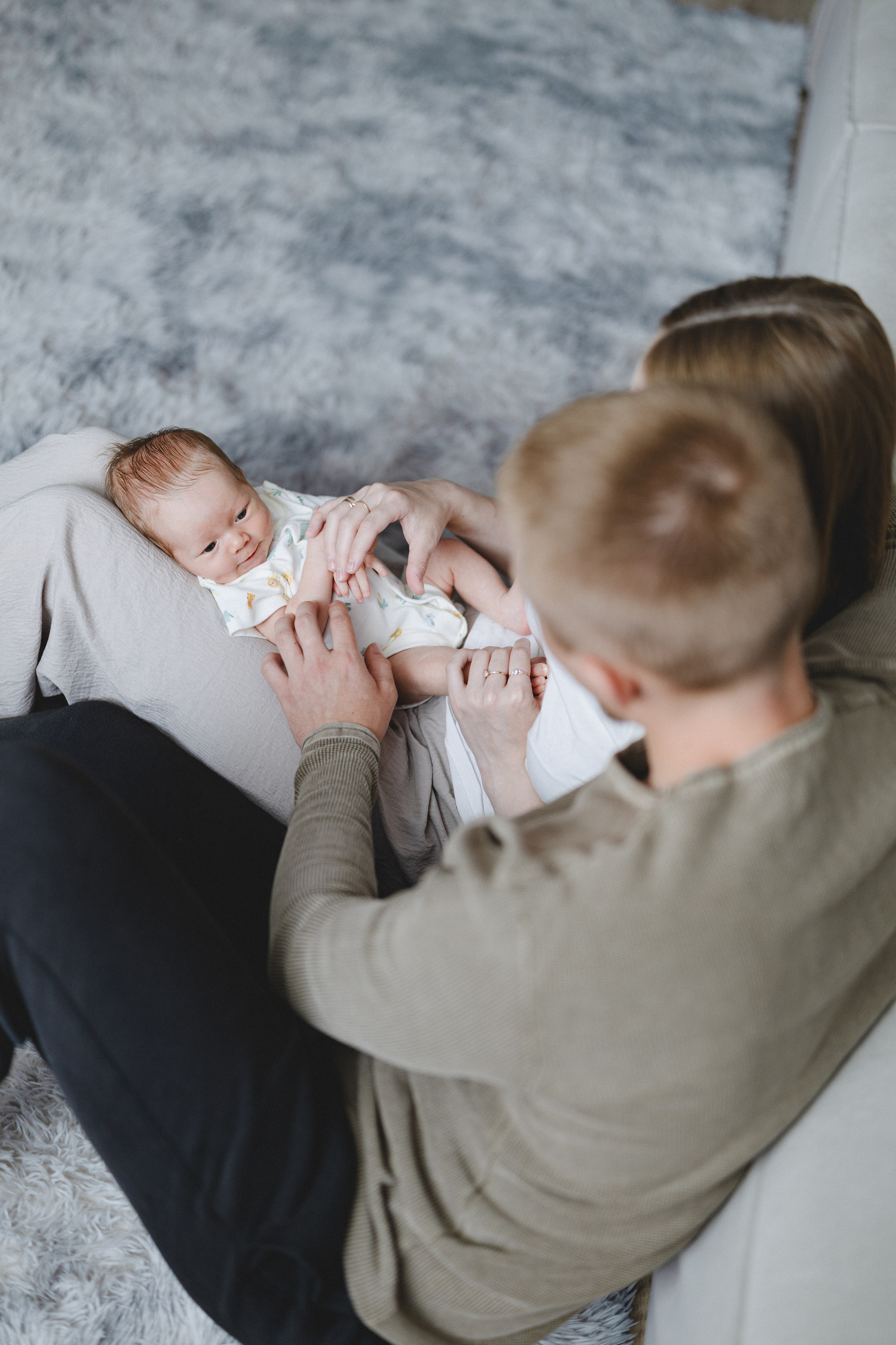 Parents looking down at their newborn resting on their laps