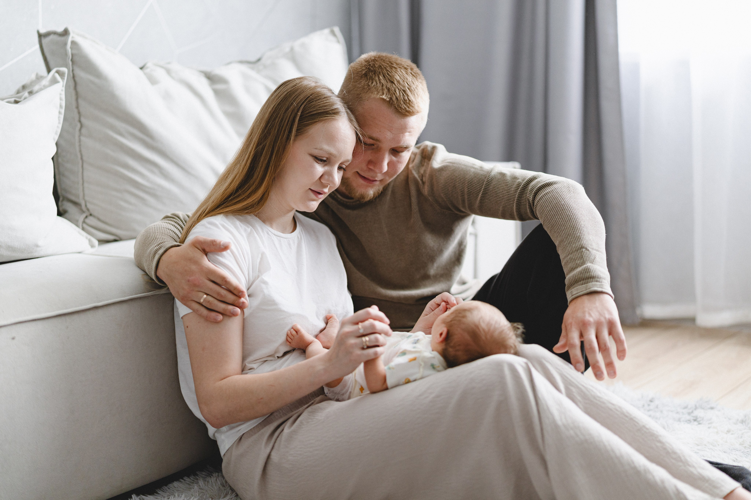 Young parents sitting at home with their newborn baby
