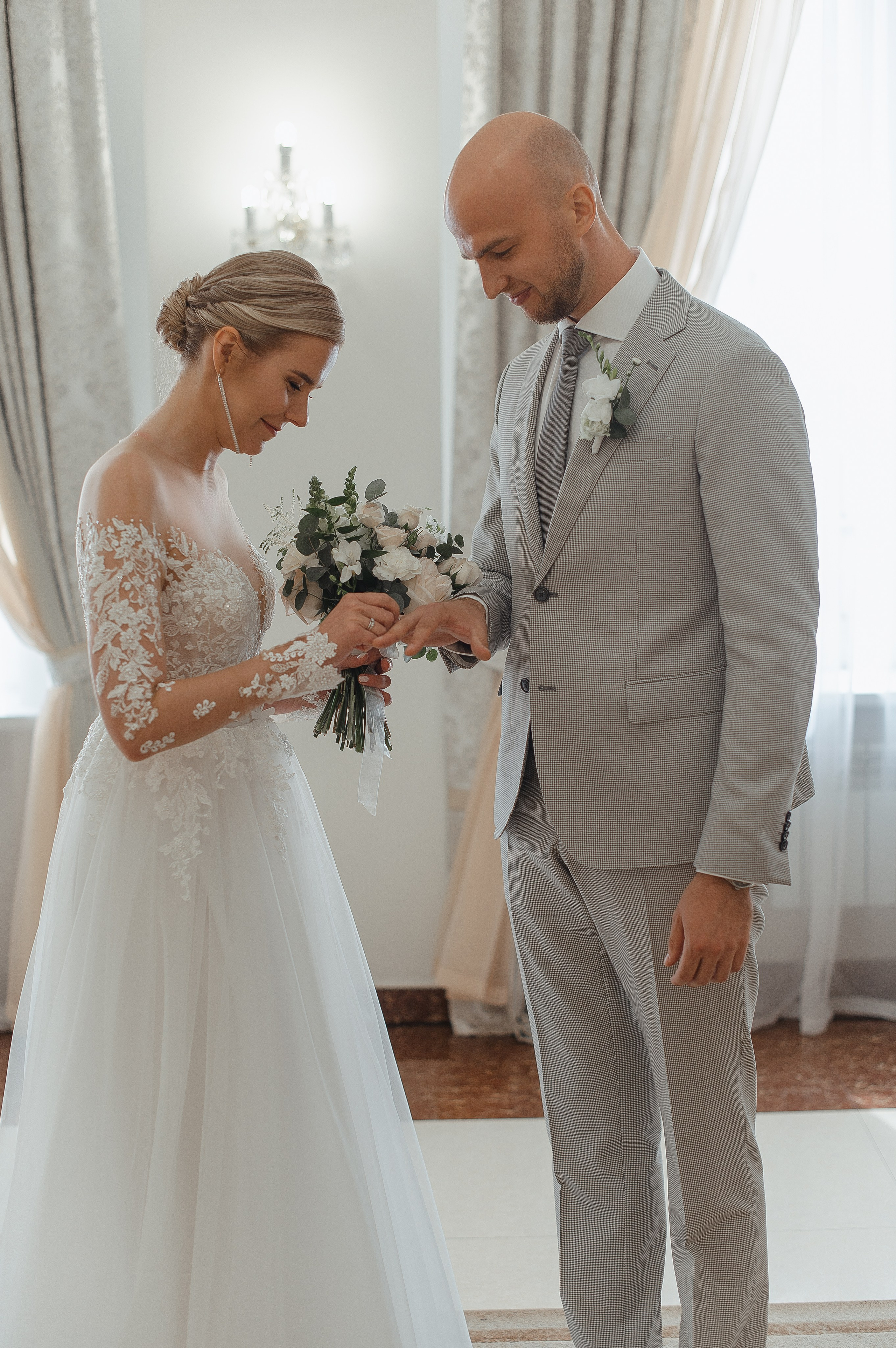 Момент бракосочетания в загсе,невеста одевает кольцо жениху на палец