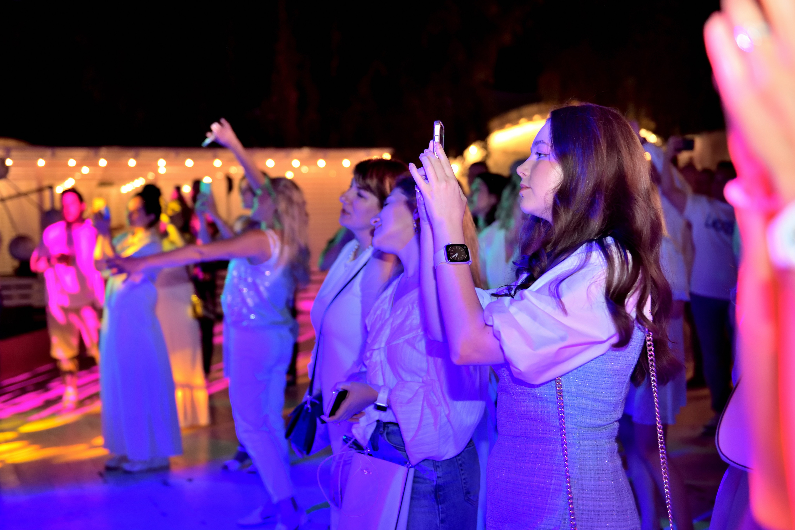 "Девушка увлеченно снимает концерт на мобильный телефон".