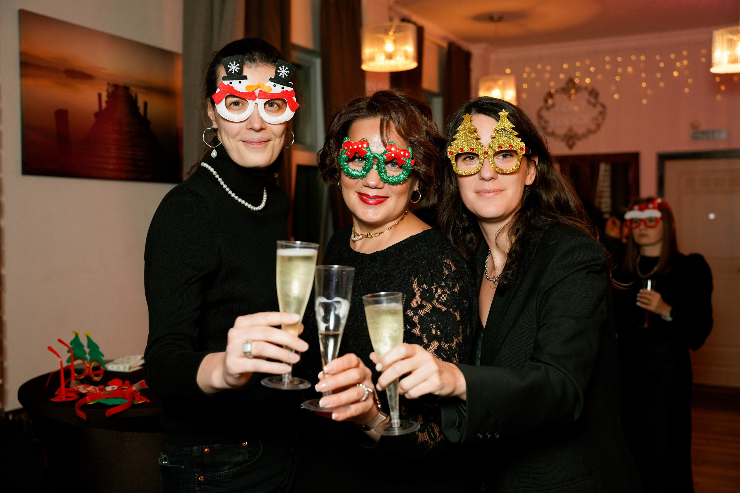 Три женщины в масках с шампанском на новогоднем корпоративе