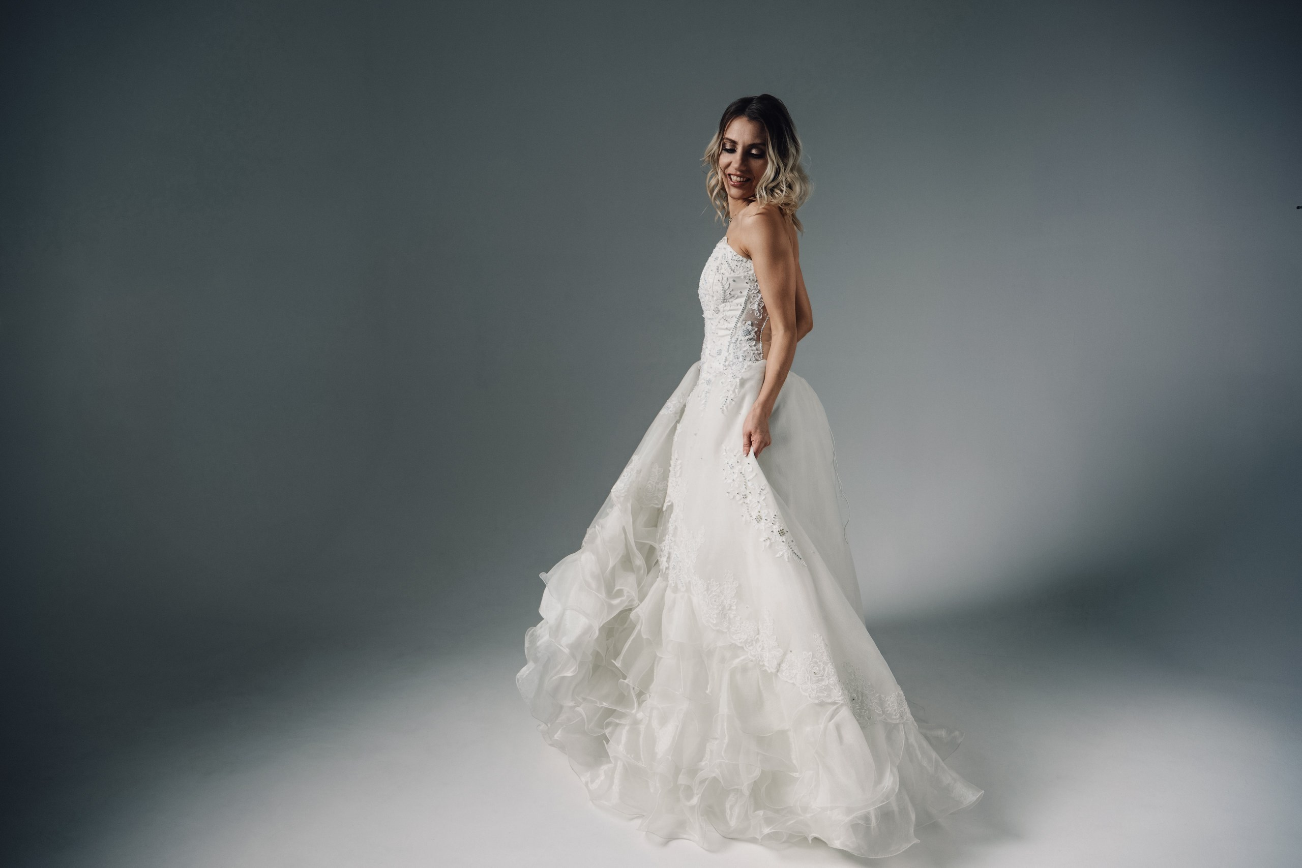 Невеста в длинном свадебном платье на студийной съемке, современная свадебная фотография