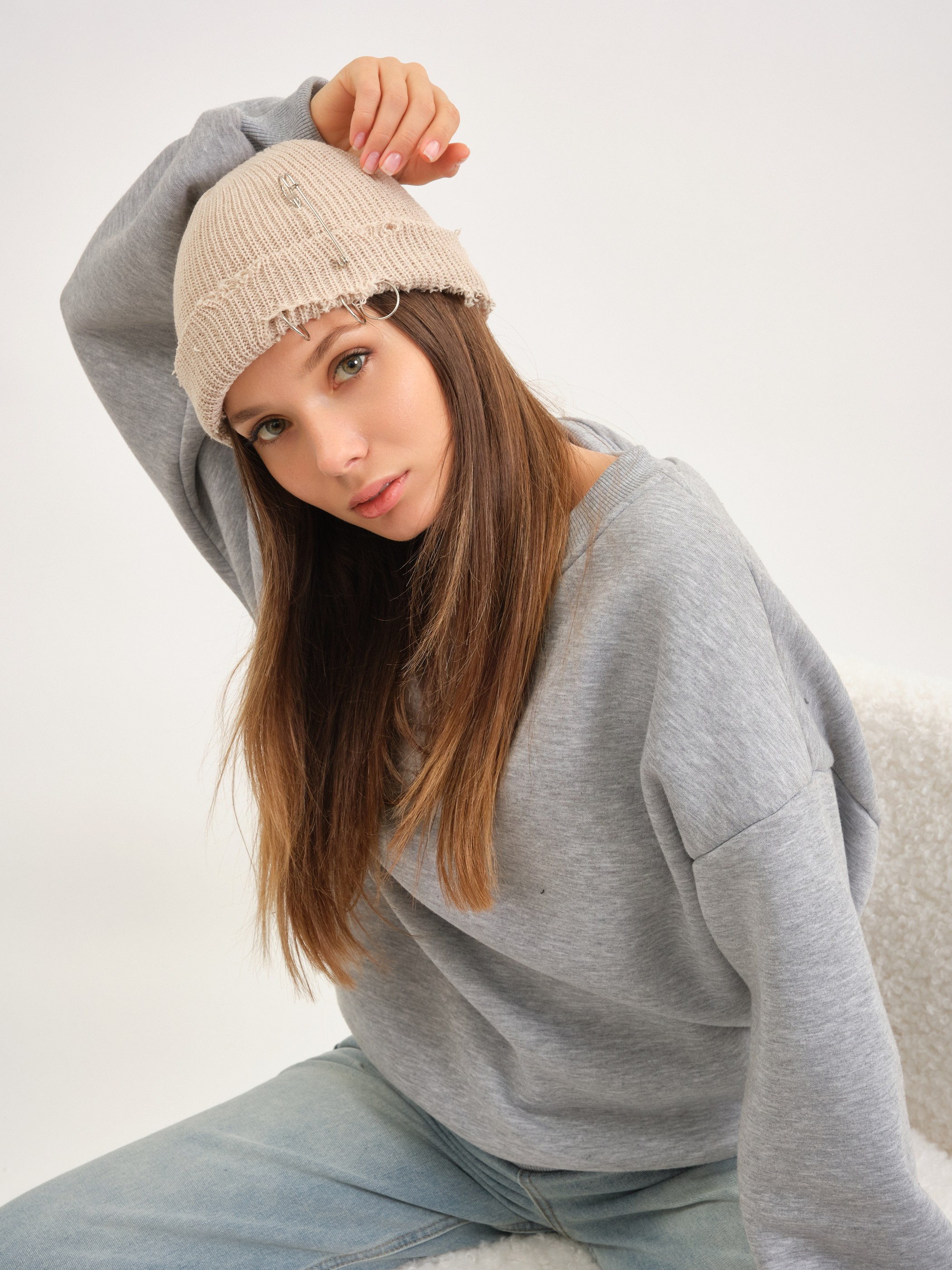 Женщина в светлом свитере, поза сидя