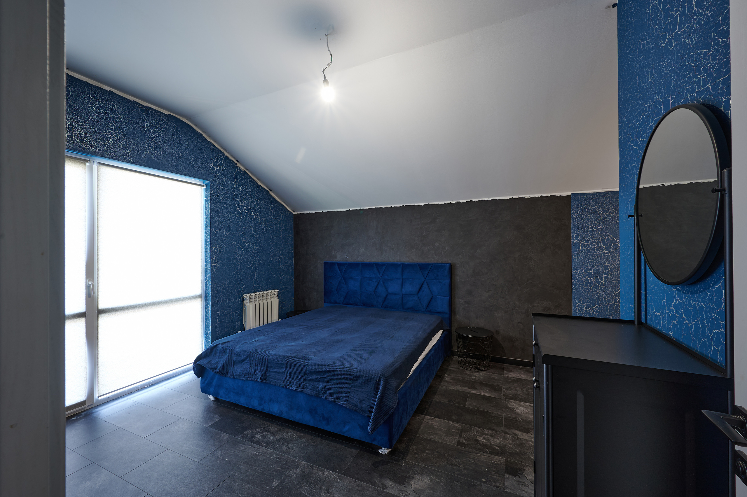 комната в синий оттенках черный комод черное круглое зеркало 