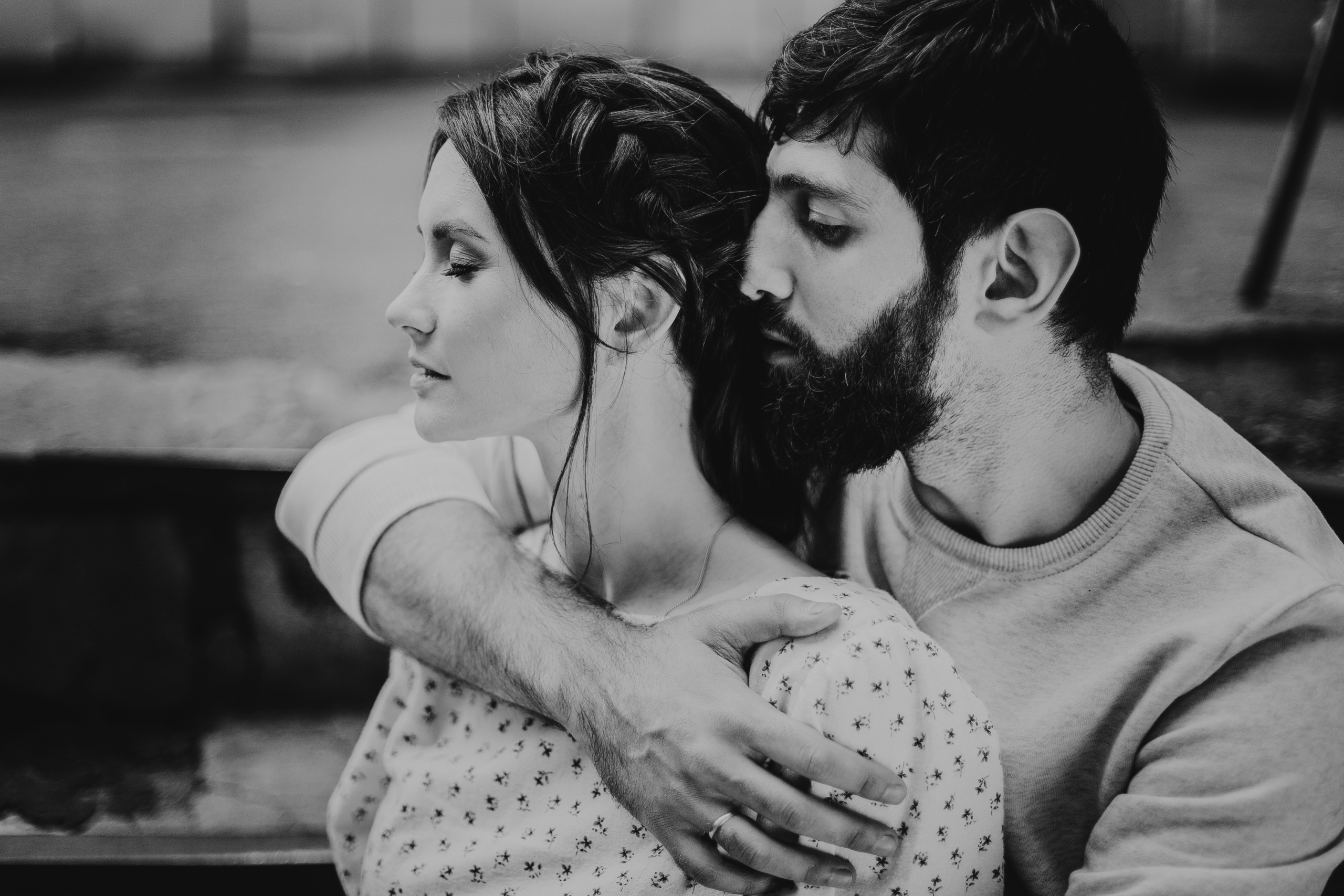 бородатый парень сзади обнимает свою девушку за плечи