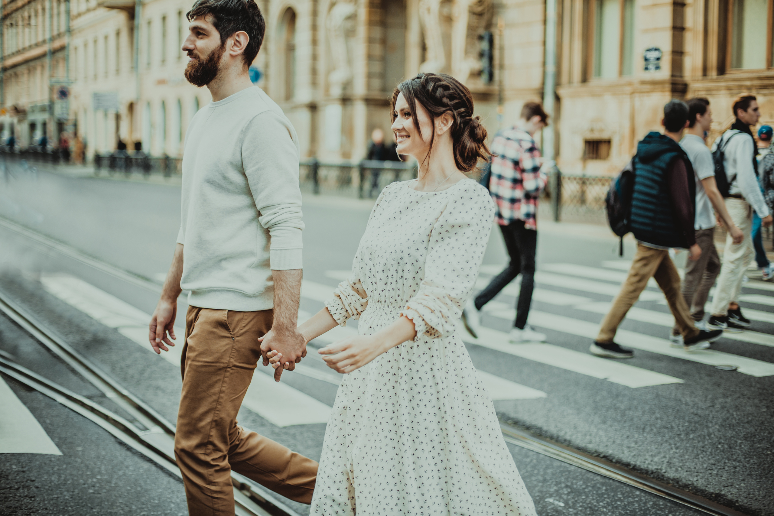 влюбленные идут взявшись за руки через пешеходный переход