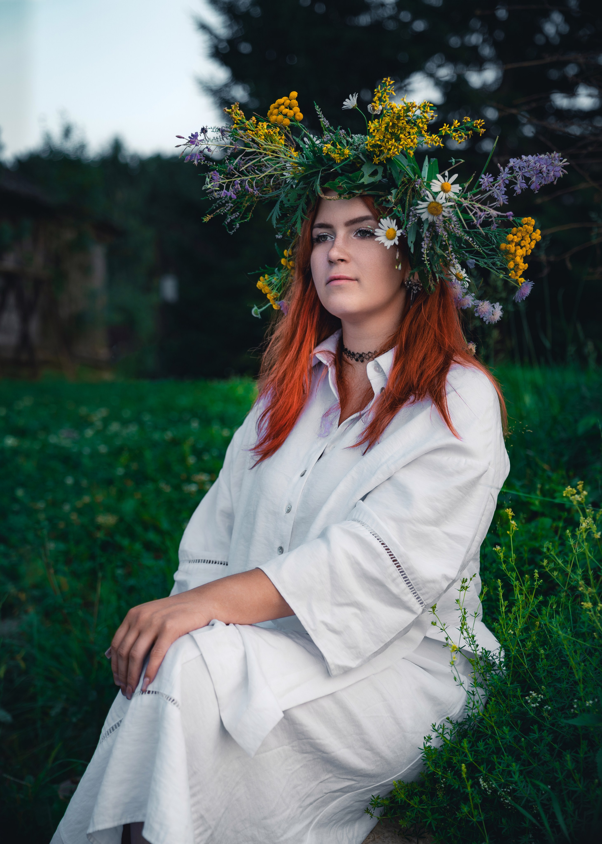 Эмоциональный портрет на природе: девушка с яркими рыжими волосами и цветочным венком, белая одежда, задумчивый взгляд .