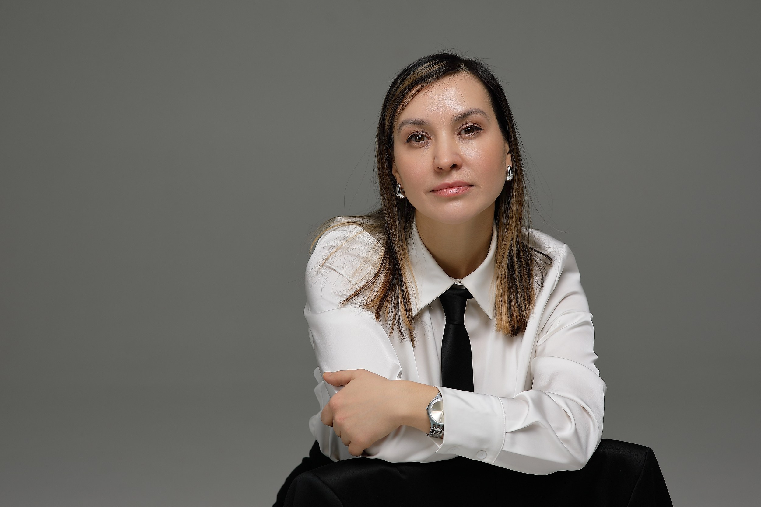 женщина в черном костюме на белом фоне в деловом стиле