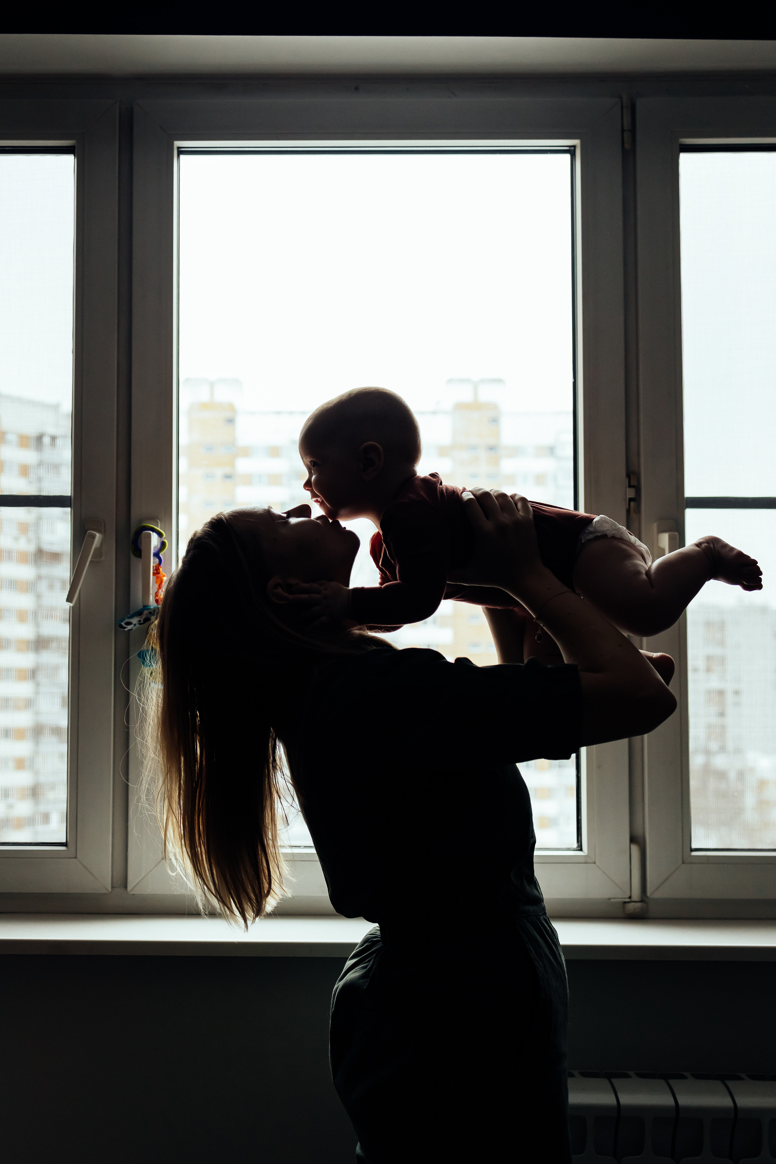 мама и малыш на фоне окна силуэт