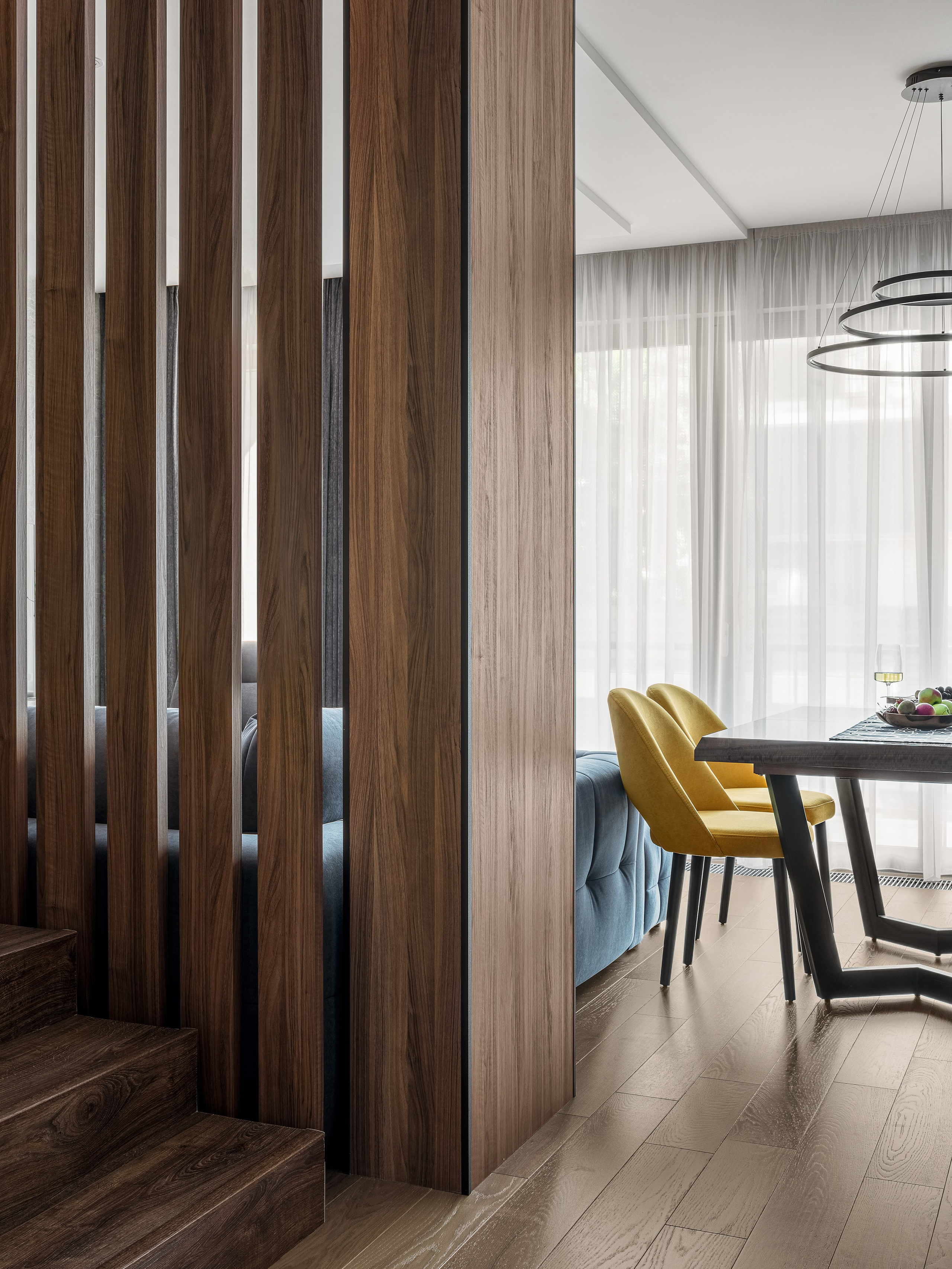 Интерьер с перегородкой из вертикальных деревянных ламелей возле лестницы, соединяющей гостиную и кухню-столовую, проект дизайнеров Алёны Поповой и Анастасии Дмитриевой, фото Сергея Денисенко.