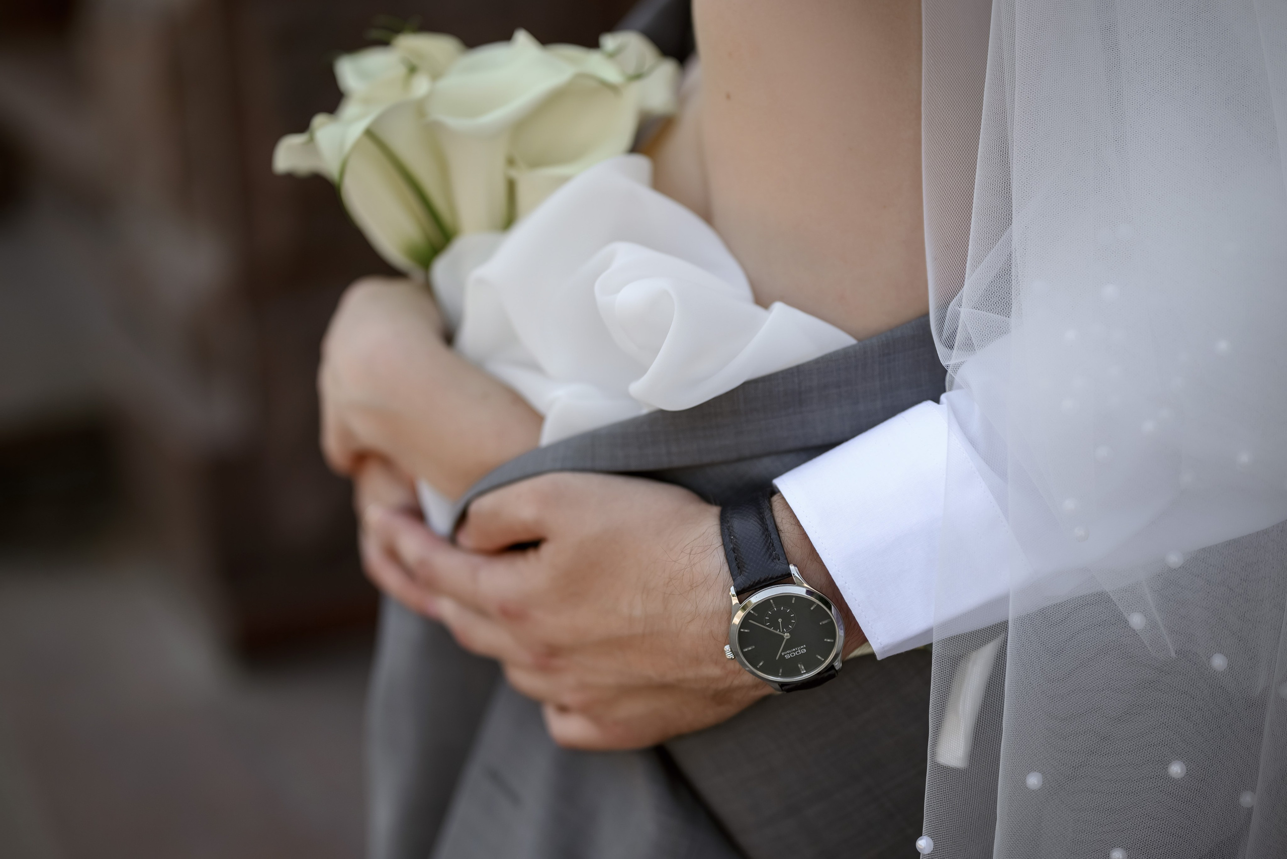 Рука парня с наручными часами обнимающая девушку