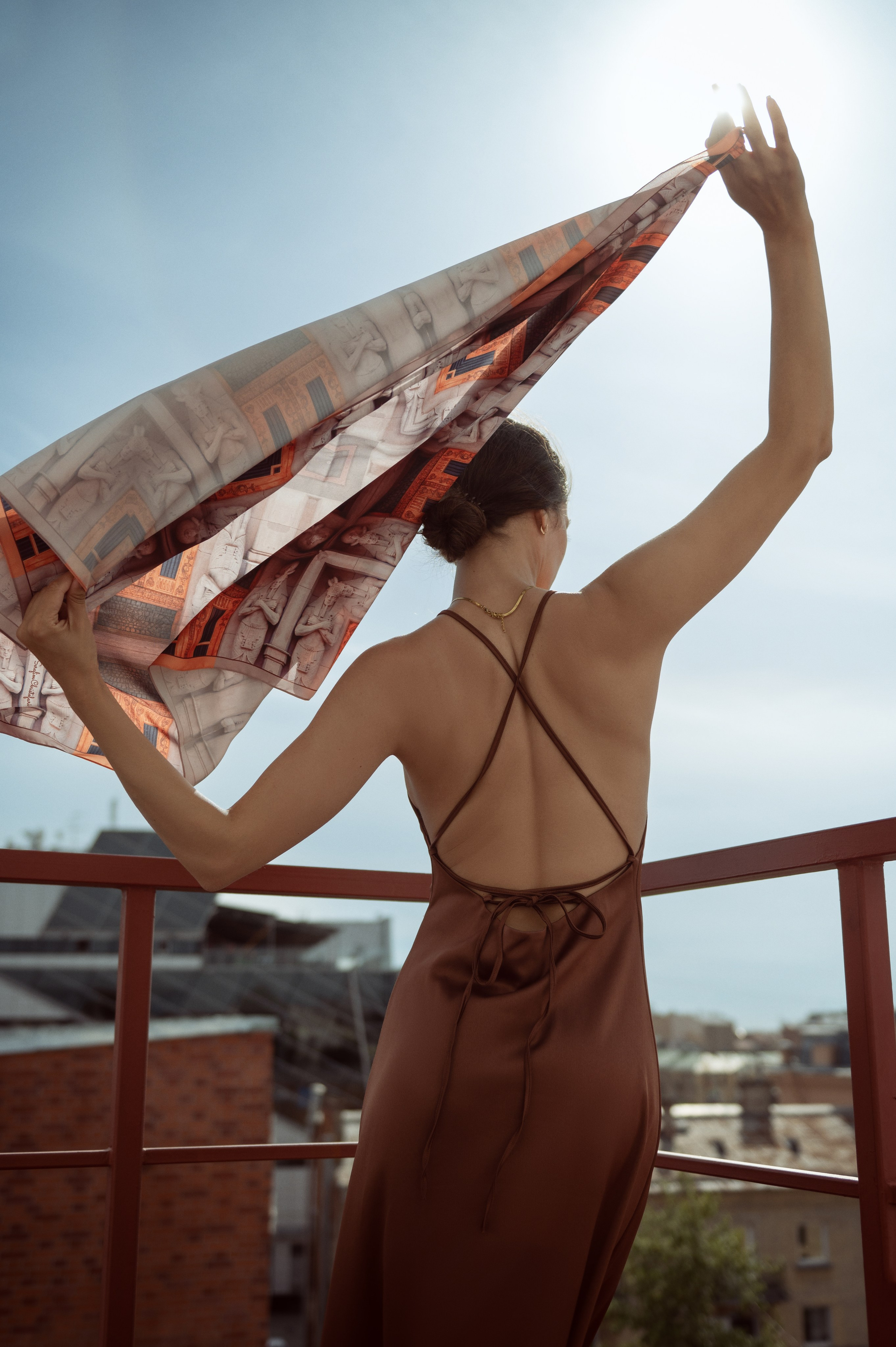 Красивая темноволосая девушка в терракотовом платье-комбинации и платком от Serafim Cristofari "Египетский дом"