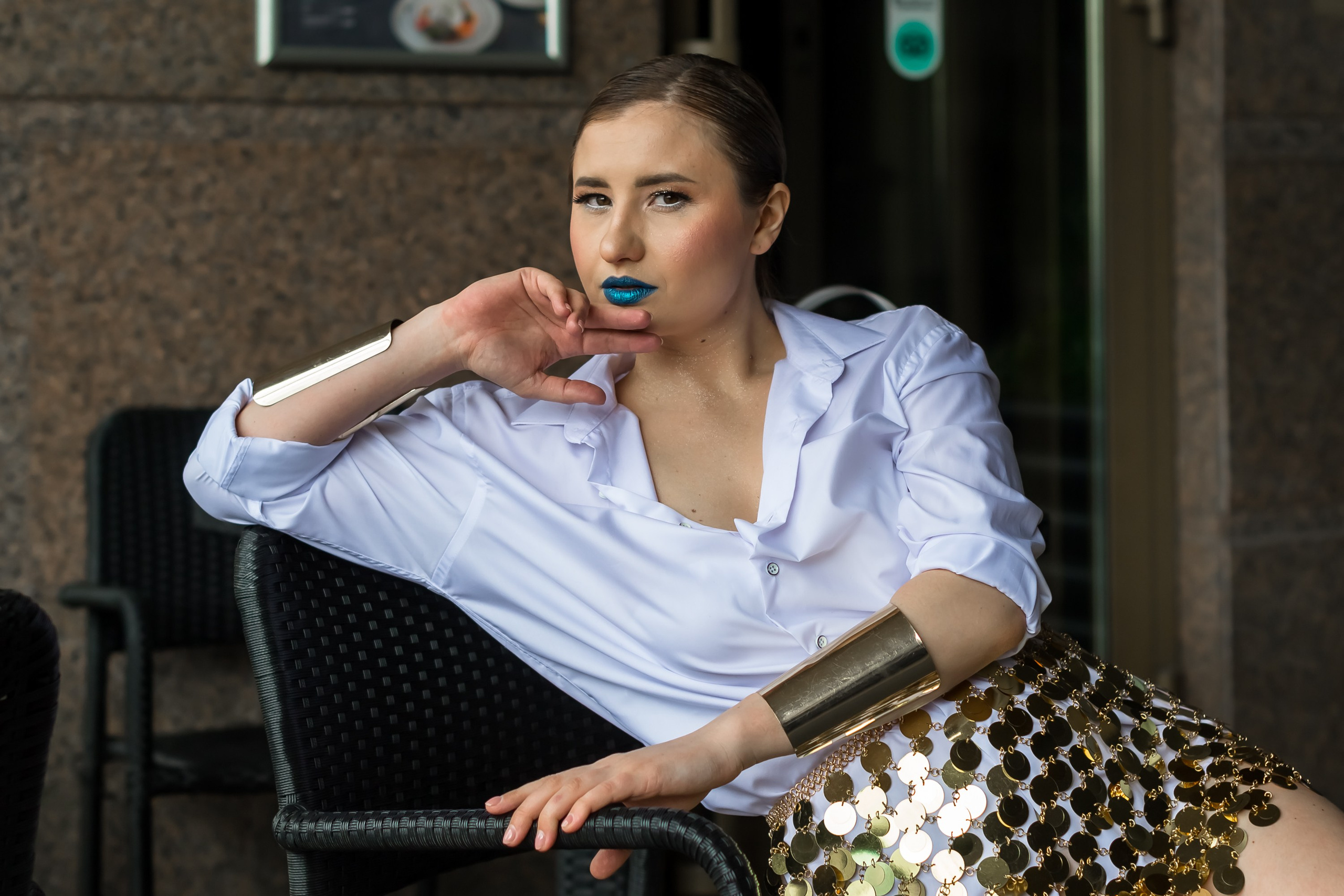 На фото девушка облокотилась на стул.