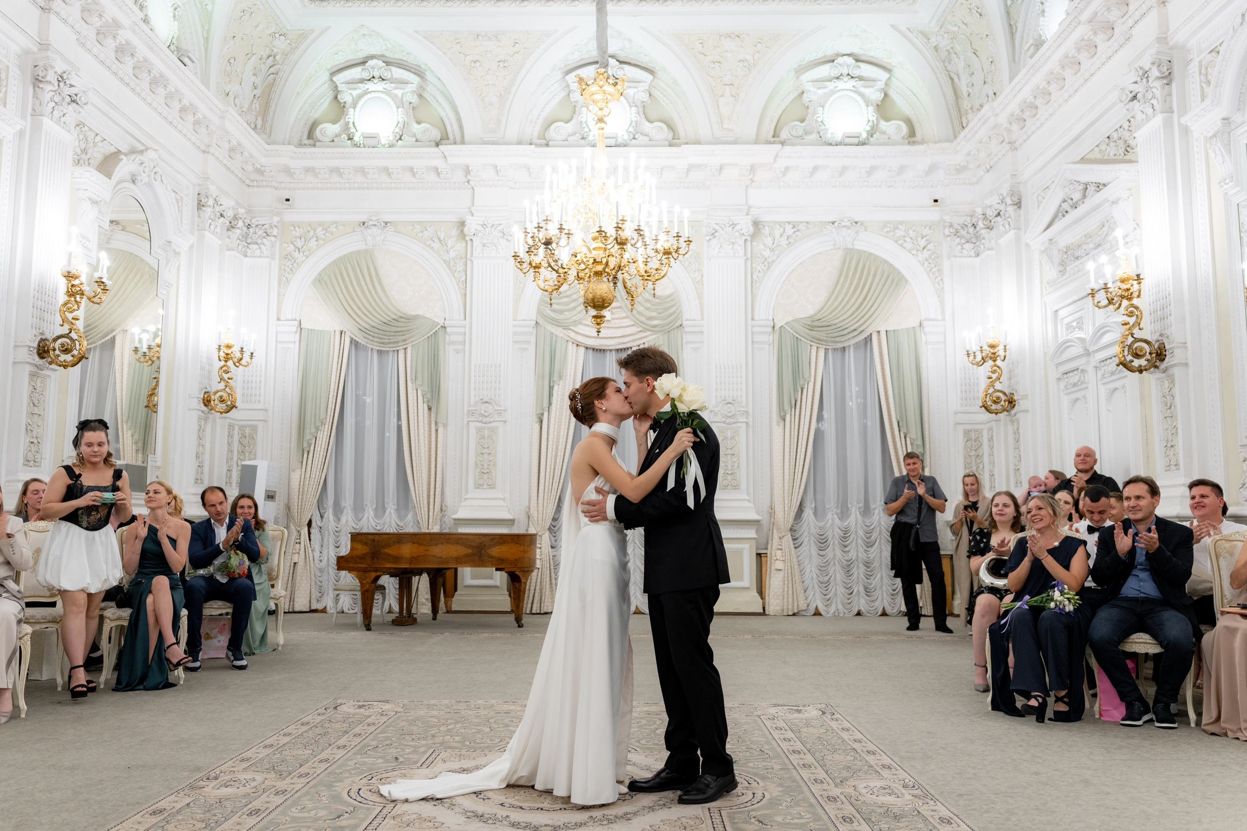 жених и невеста целуются после росписи в зале регистрации во дворце на английской набережной