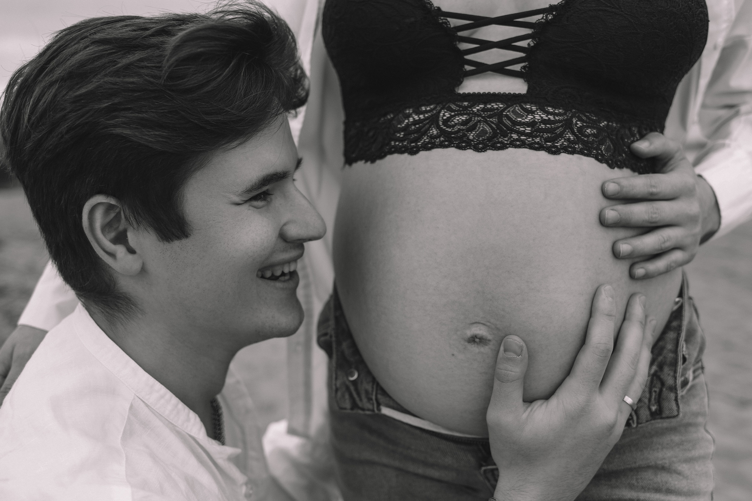 Мужчина целует живот беременной, нежный момент