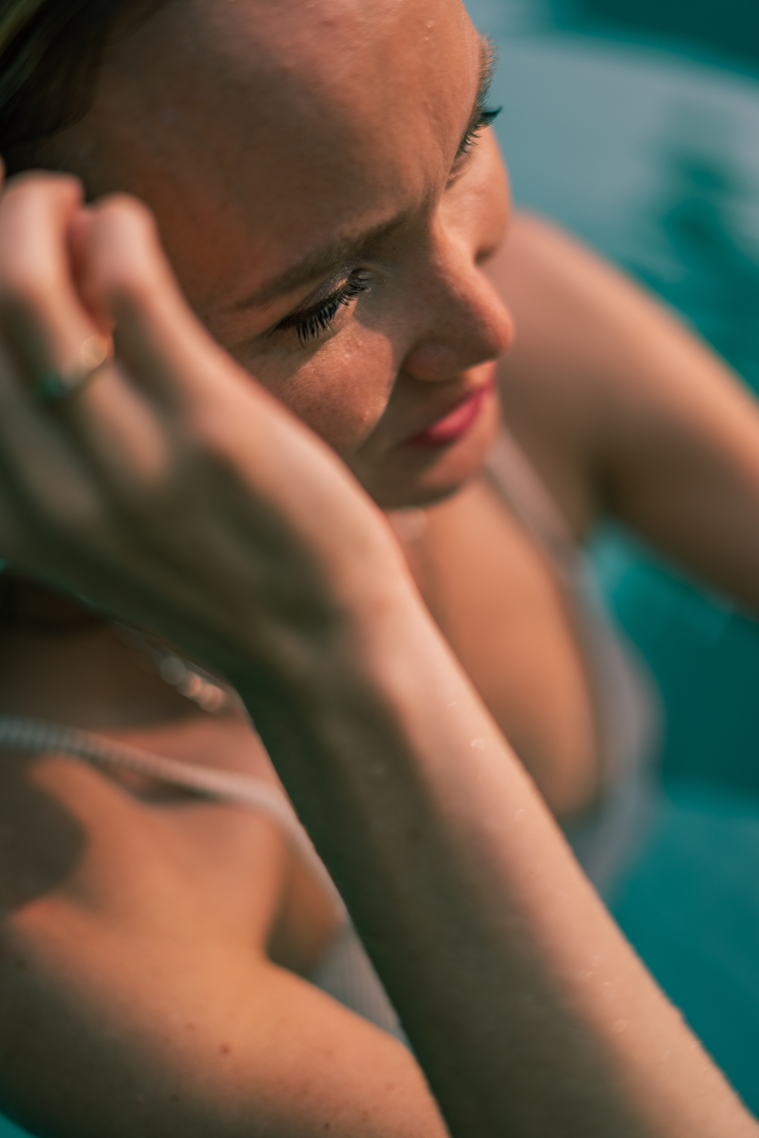 a girl in a white swimsuit relaxing on a lounger by the pool