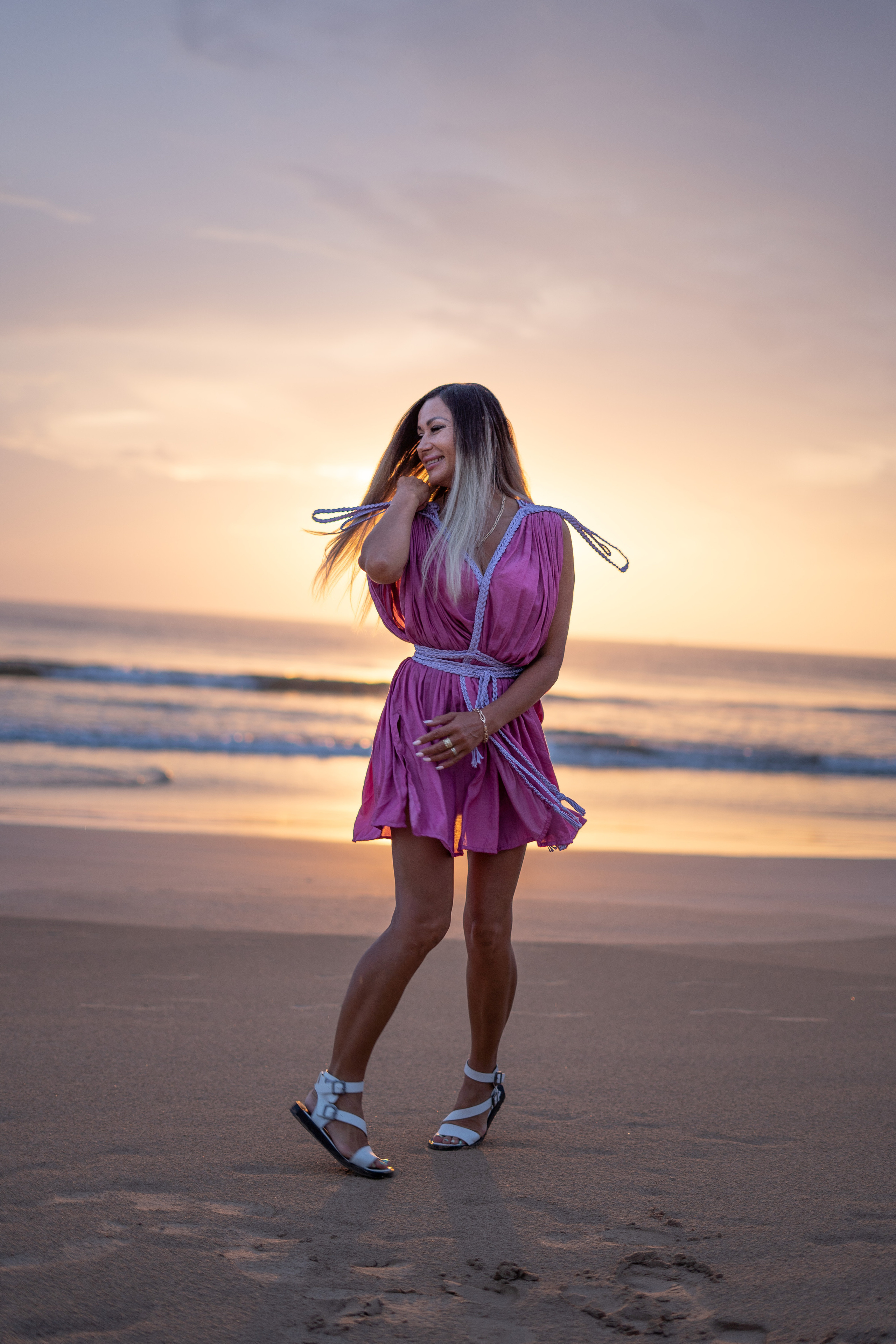 a beautiful girl watching the sunset over the ocean
