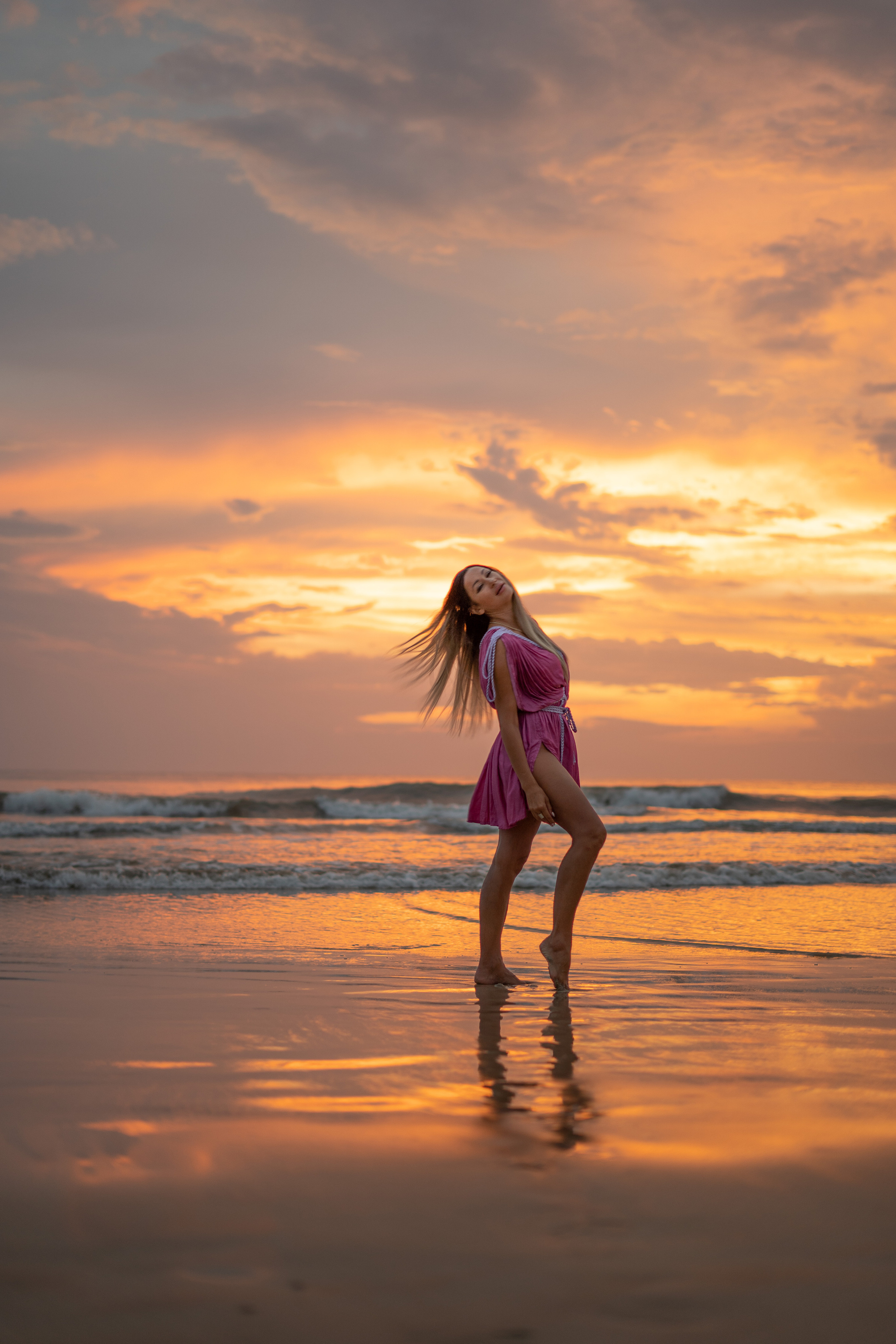 a girl enjoying the sunset by the ocean